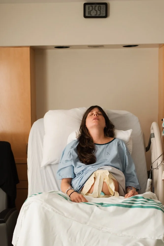 Femme hospitalisée allongée dans un lit d'hôpital, portant une robe d'hôpital, avec un bandage à l'abdomen, dans une chambre d'hôpital