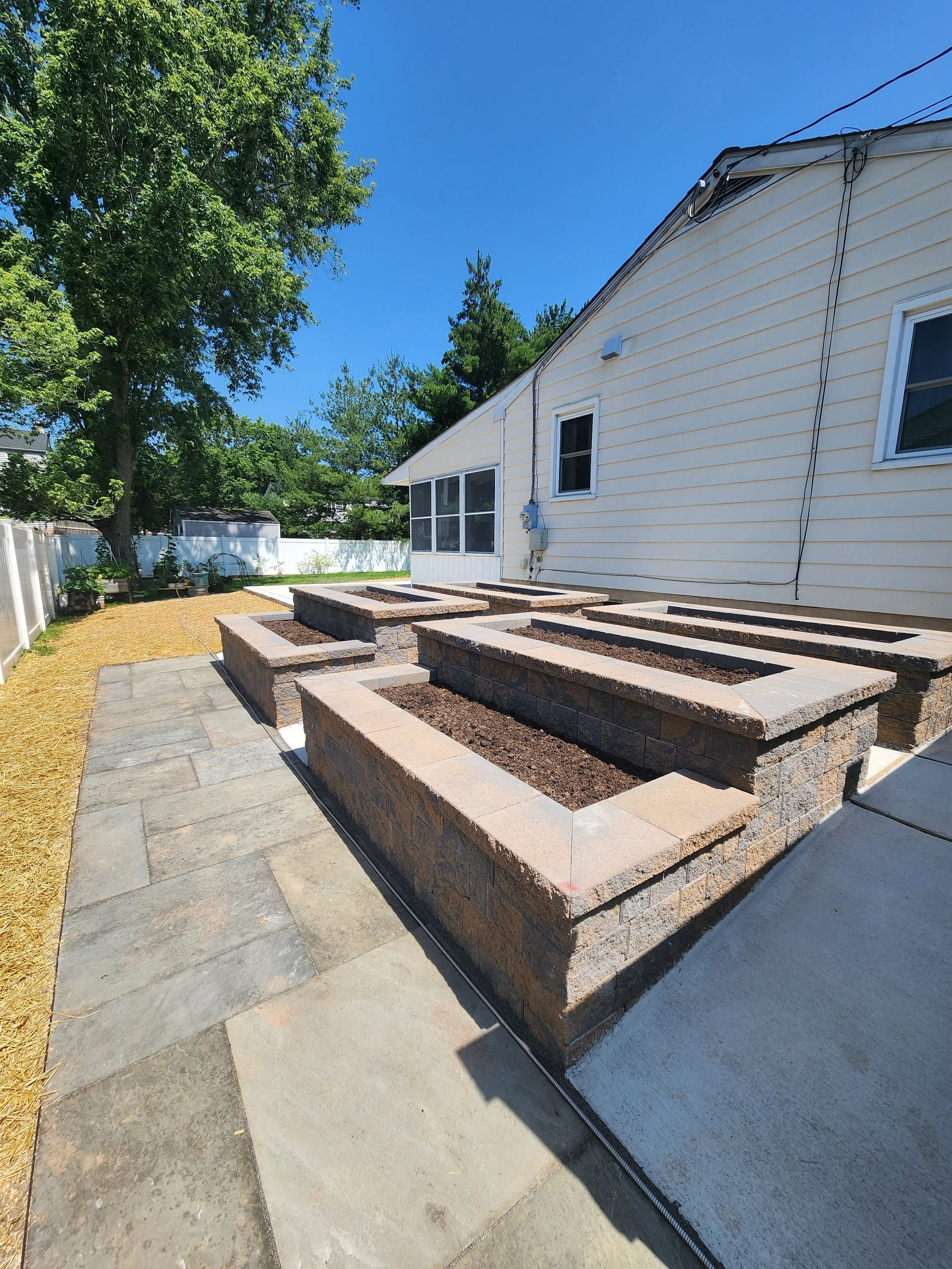 One of a kind custom designed patio. Bluestone, concrete, and retaining wall block. The patio wraps around 3 sides of the house. Six raised garden beds. We are SO proud!