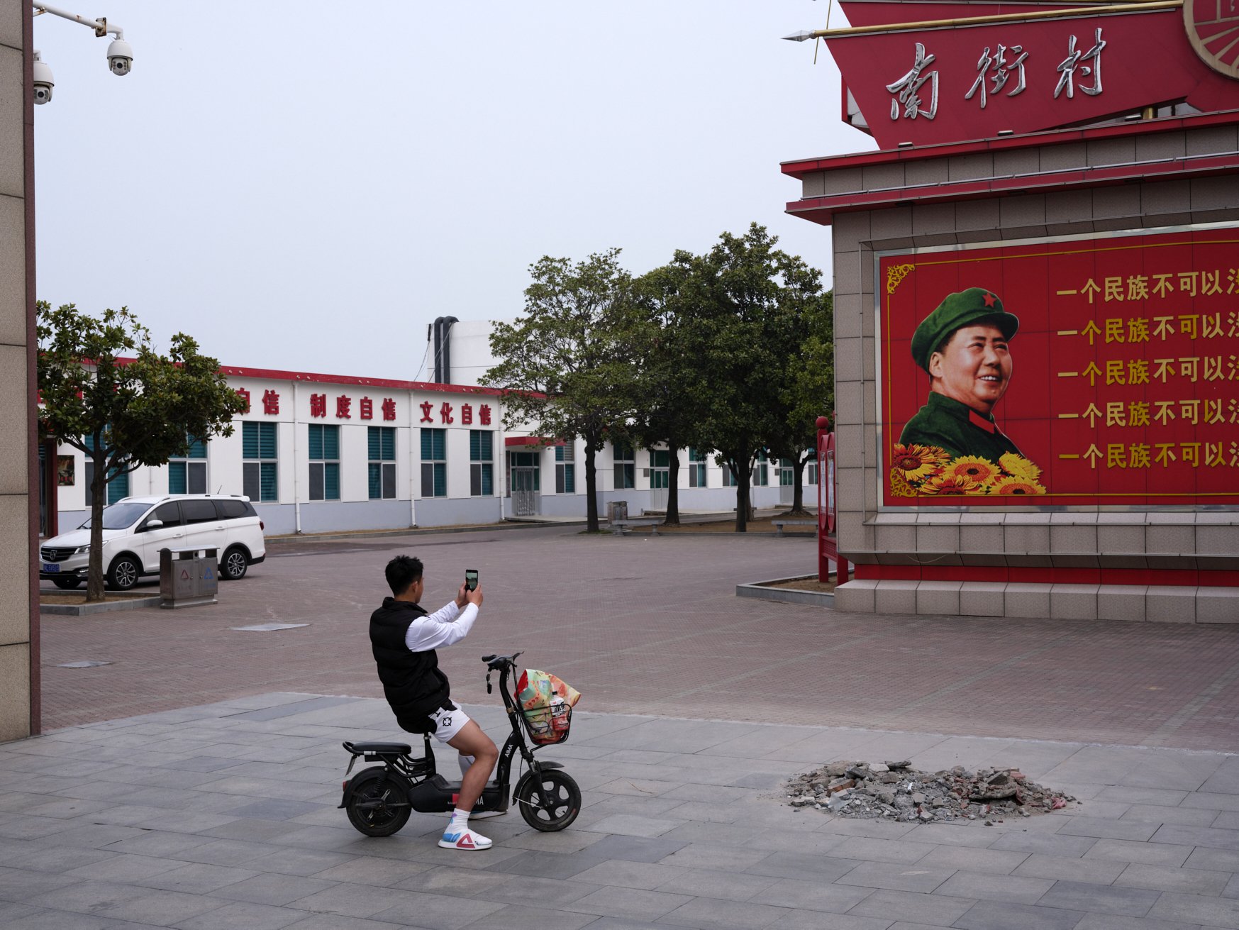 Man taking photo of Mao Zedong. Nanjie, China, 2024