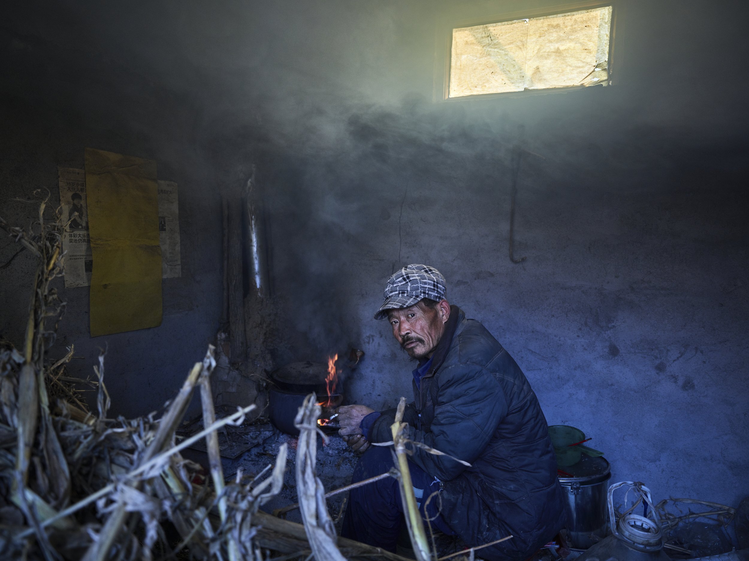 Hu Guangzhou cooking. Months later fire broke out and destroyed his home. He was then forcefully taken to live at the psychiatric hospital again. Shandong, China, 2016