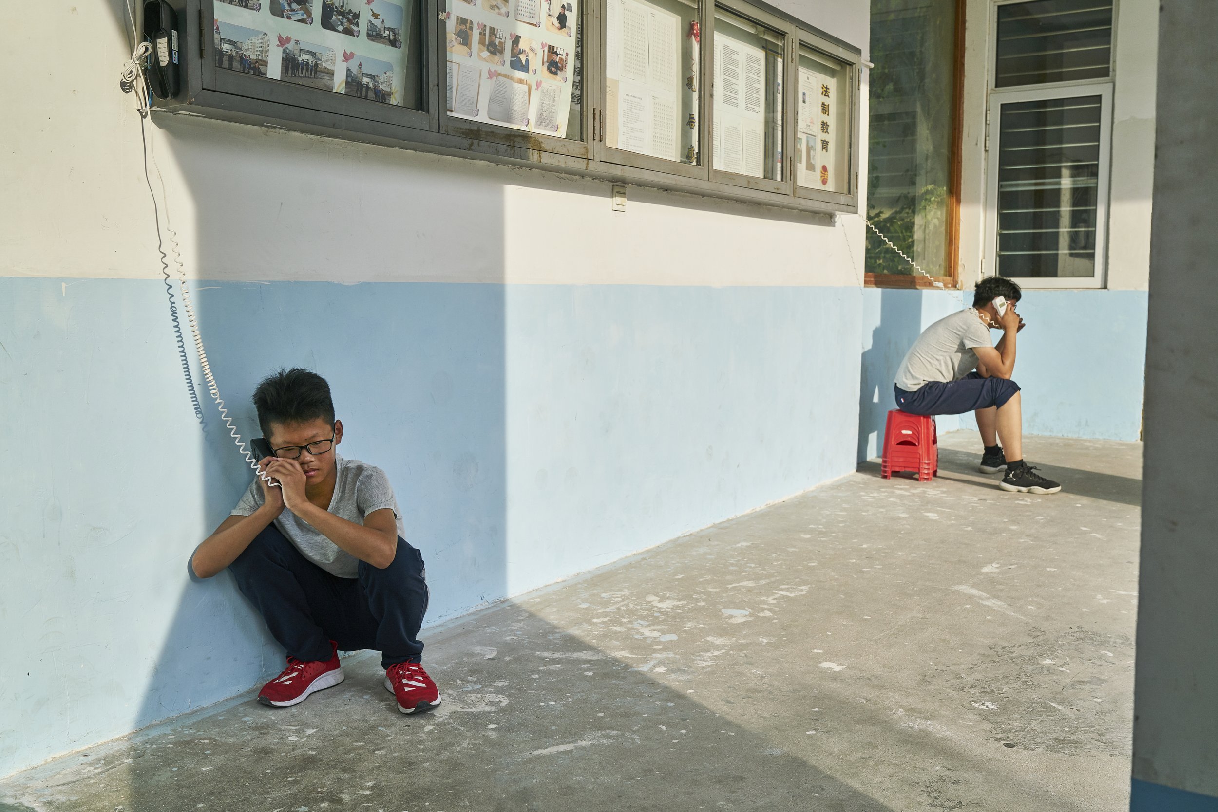 Boy at internment camp crying while calling his father. China, 2019