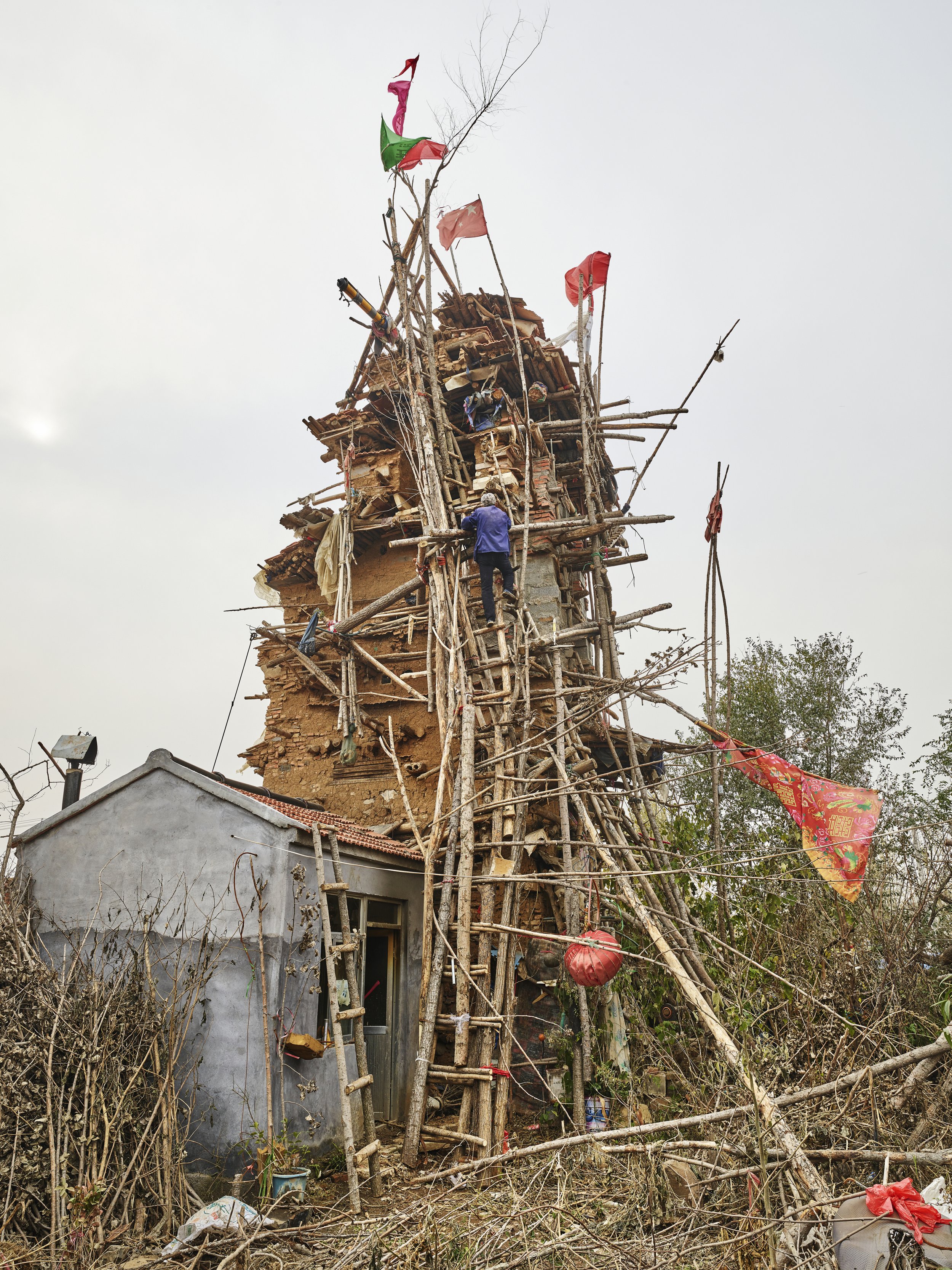 Hu Guangzhou climbing his tower. He believes the tower will bring him to heaven and reunite him with his deceased family. Shandong, China, 2016
