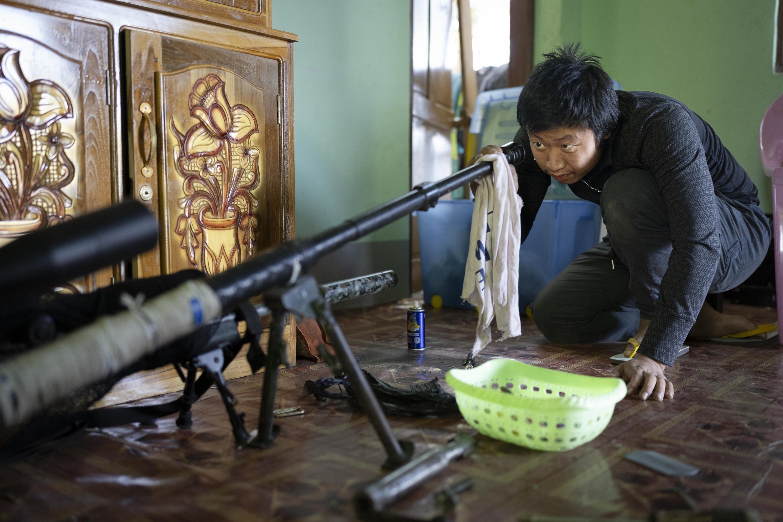 Karenni sniper cleaning his gun. Loikaw, Myanmar, 2023
