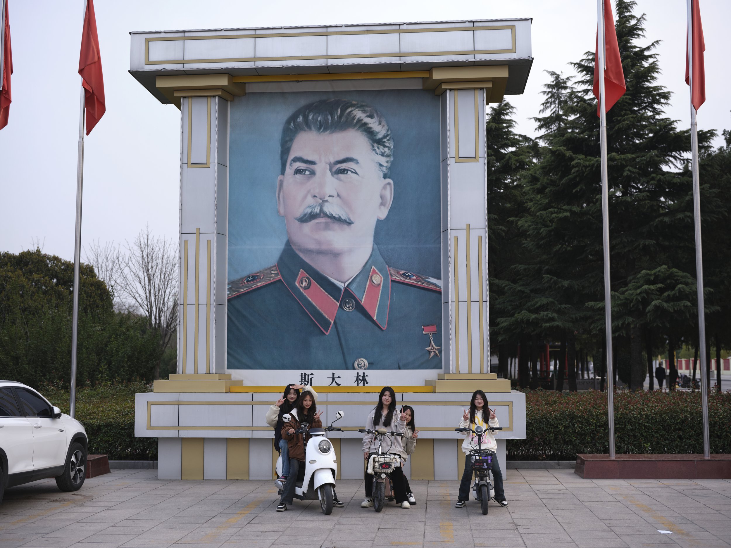 Youth posing under a portrait of Joseph Stalin. Nanjie, China, 2024