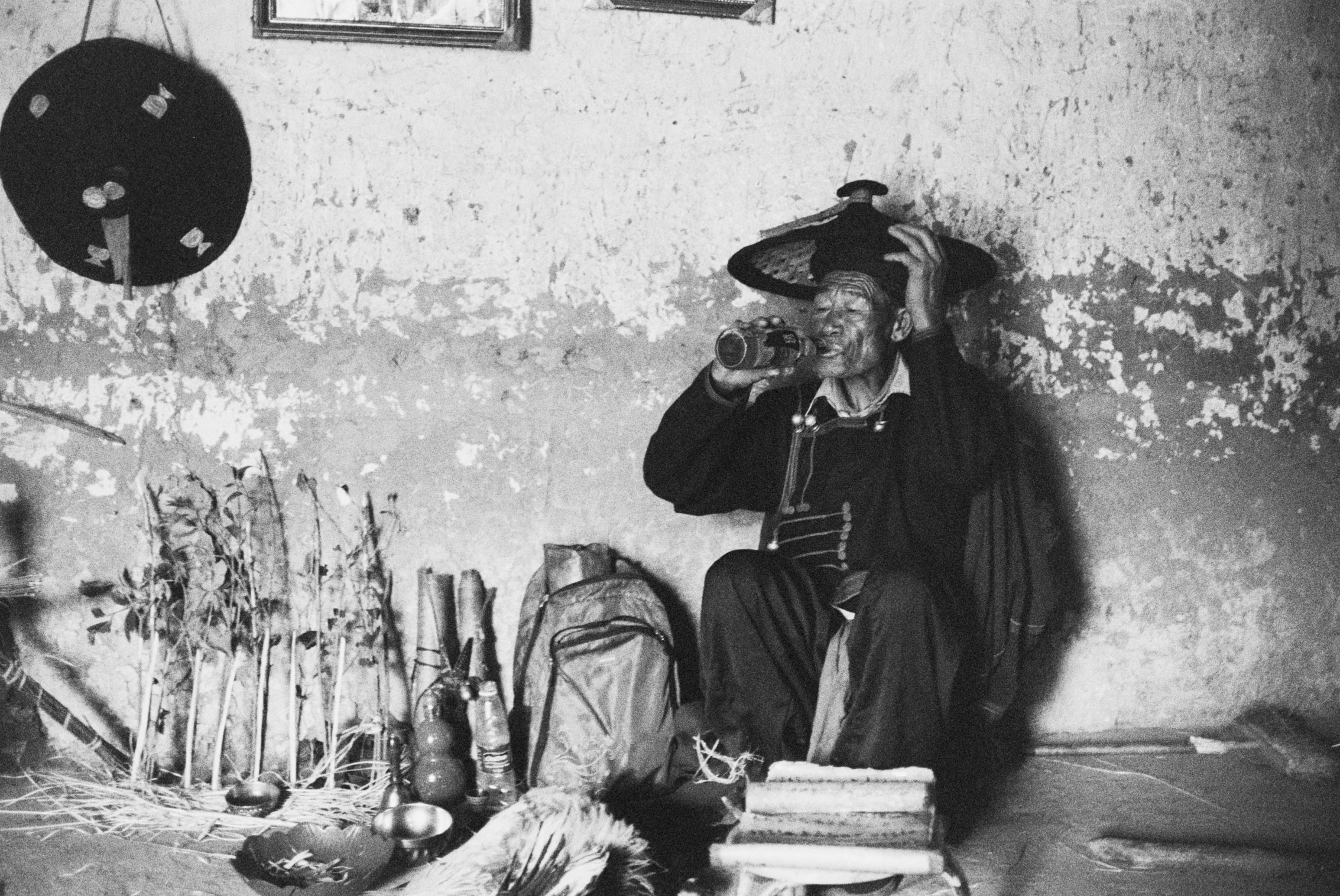 Yi shaman drinking during ritual. Liangshan Yi Autonomous Prefecture, China, 2019
