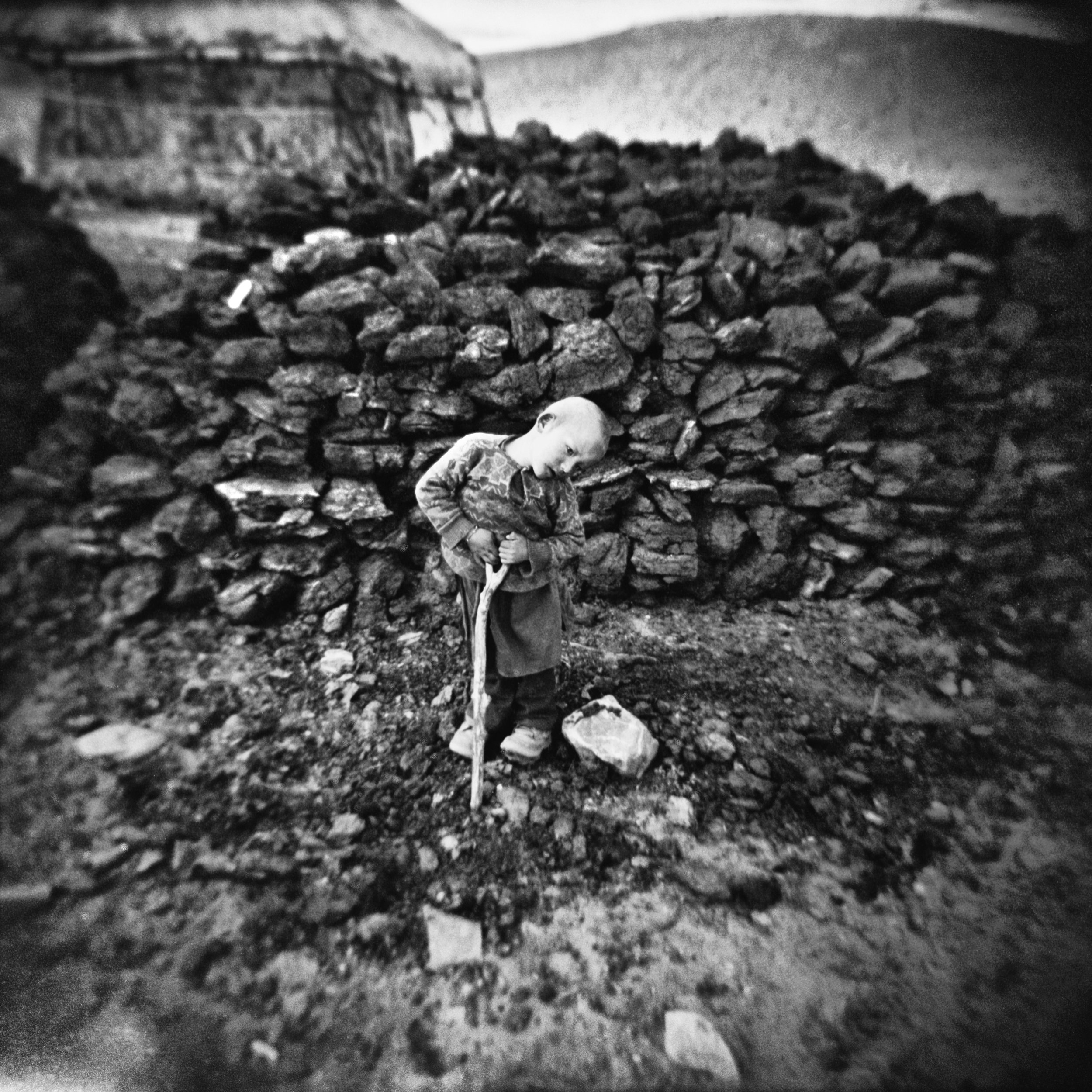 Kyrgyz boy with his favorite stick in Bozai Gumbaz, former Soviet outpost. Wakhan corridor, Afghanistan, 2009