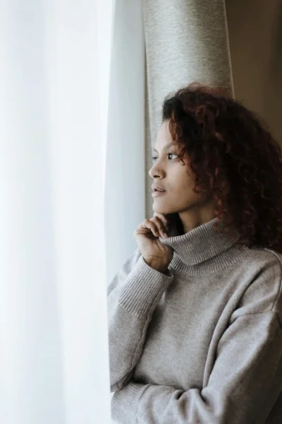 Woman standing at window looking out