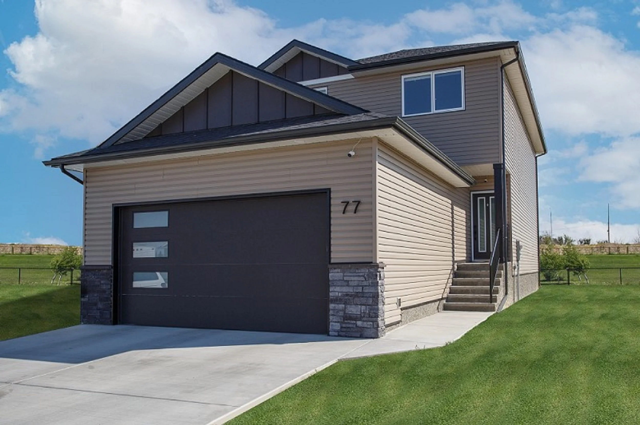 Classic home exterior tan siding grey stonework attached garage