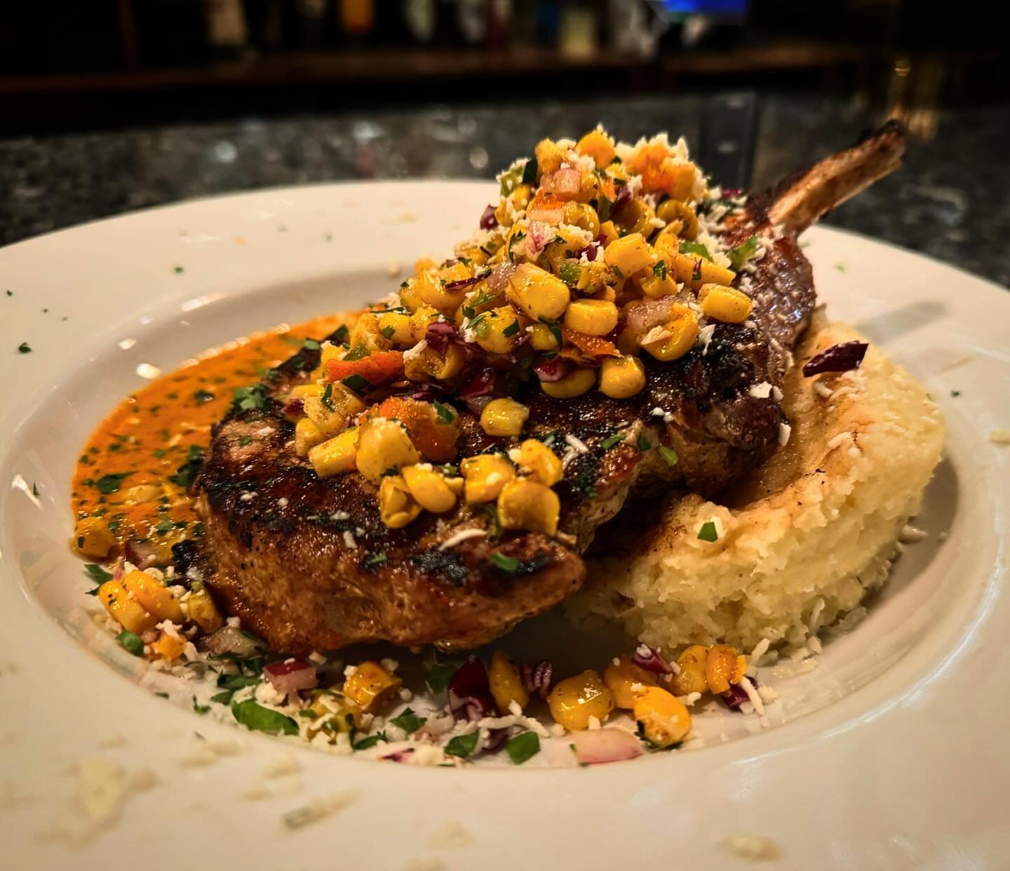 Bone-in pork chop special tonight! Grilled and topped with chipotle cream sauce and corn salsa. 🤩