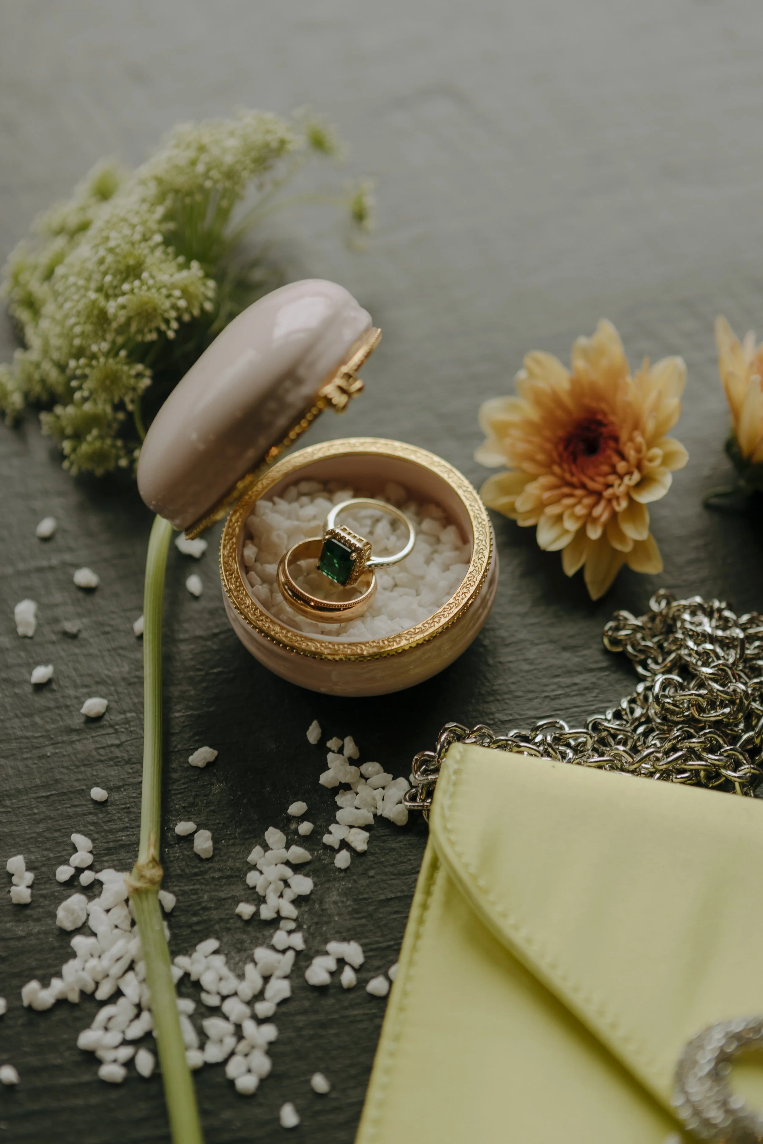 A bride and groom sharing a kiss in a rustic indoor wedding venue with brick walls and wooden floors, surrounded by empty chairs.