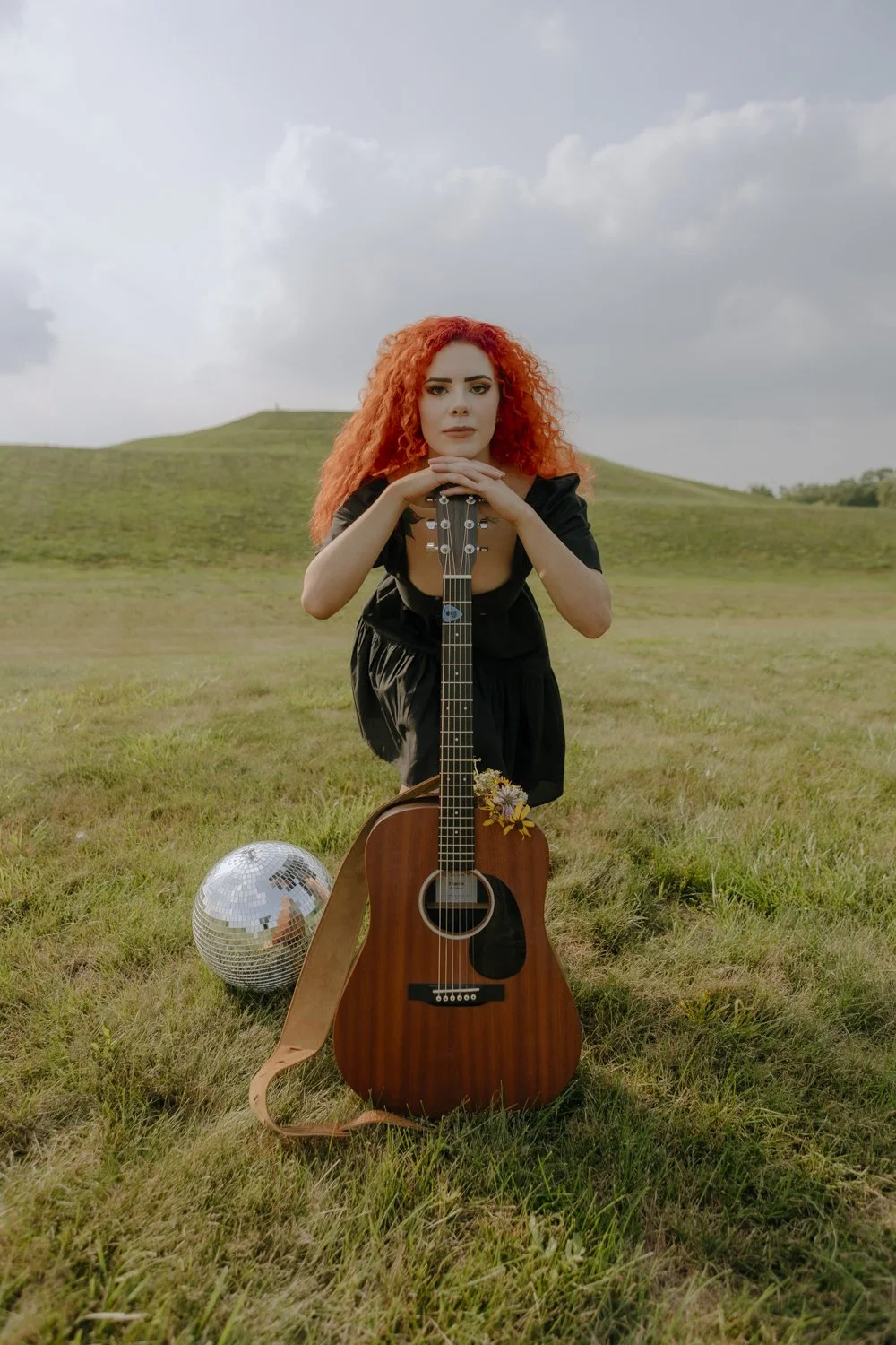 A woman lying on a bed with her eyes closed, getting a cosmetic or dermatological treatment on her eyebrows from a professional wearing black gloves.