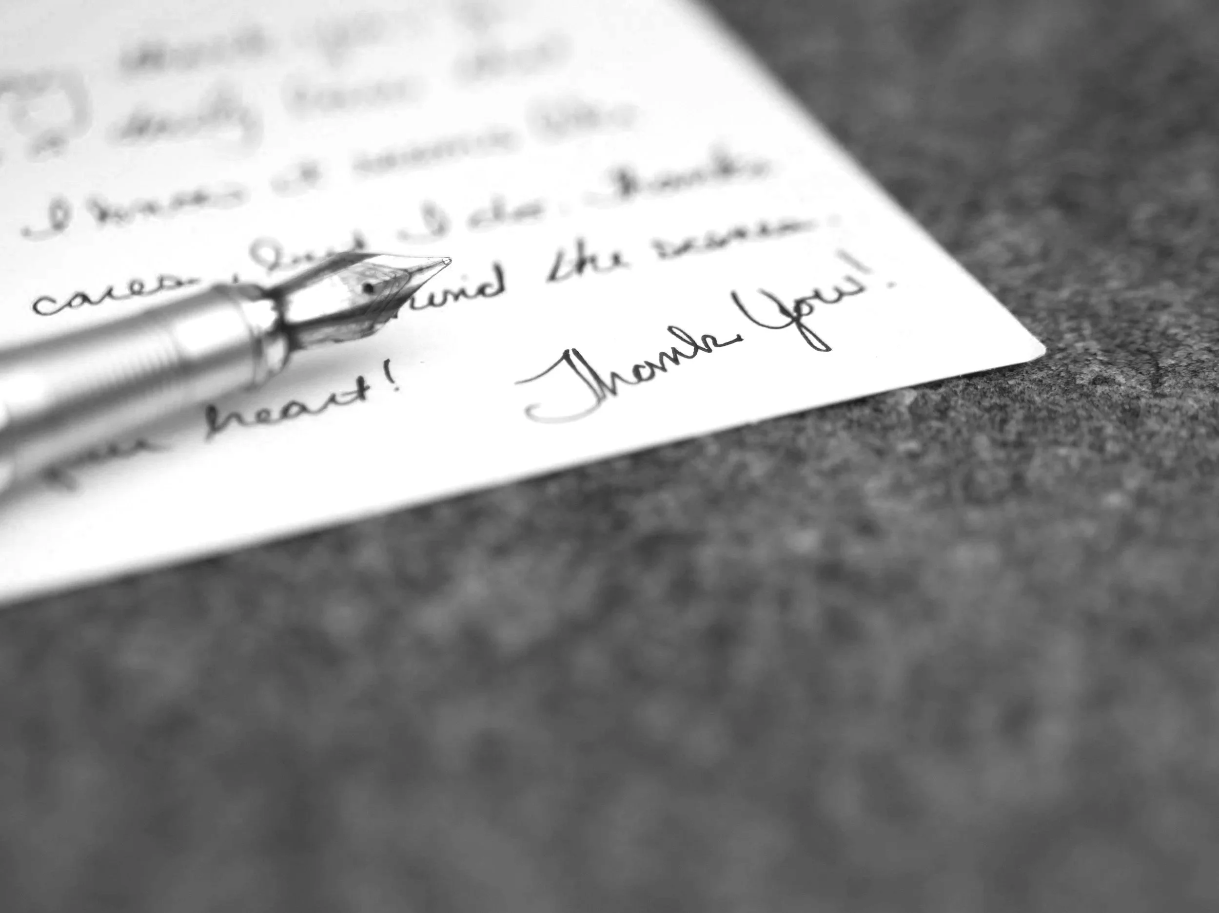 mustekynä ja käsin kirjoitettu kiitoskirje paperilla, jossa lukee 'Thank You!'