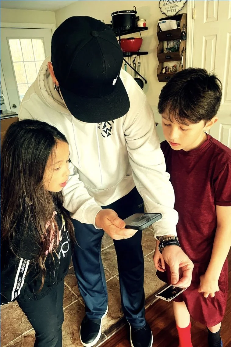 A dad showing his kids scripture coming alive on a phone