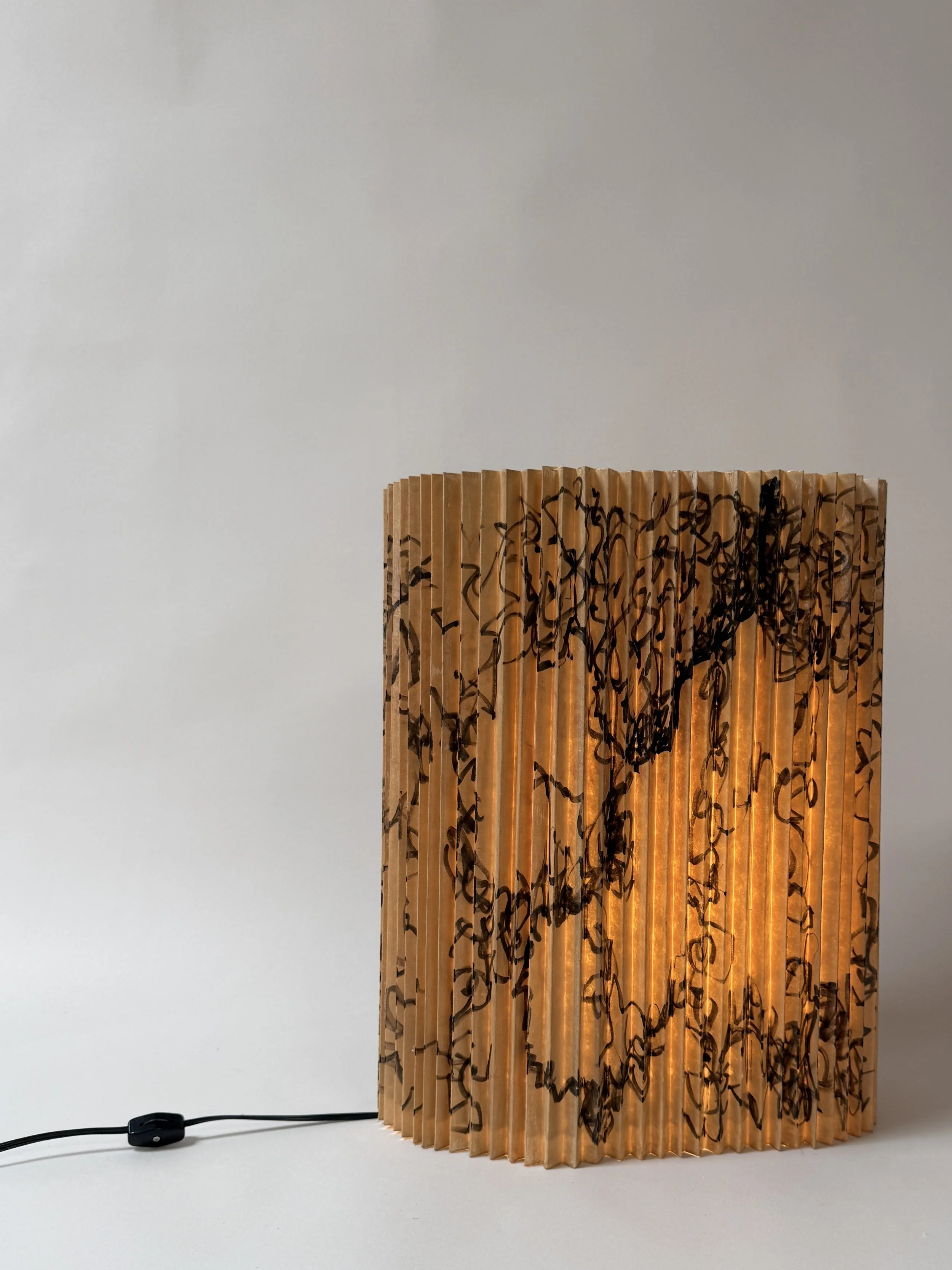 Pleated paper lamp with illustration.