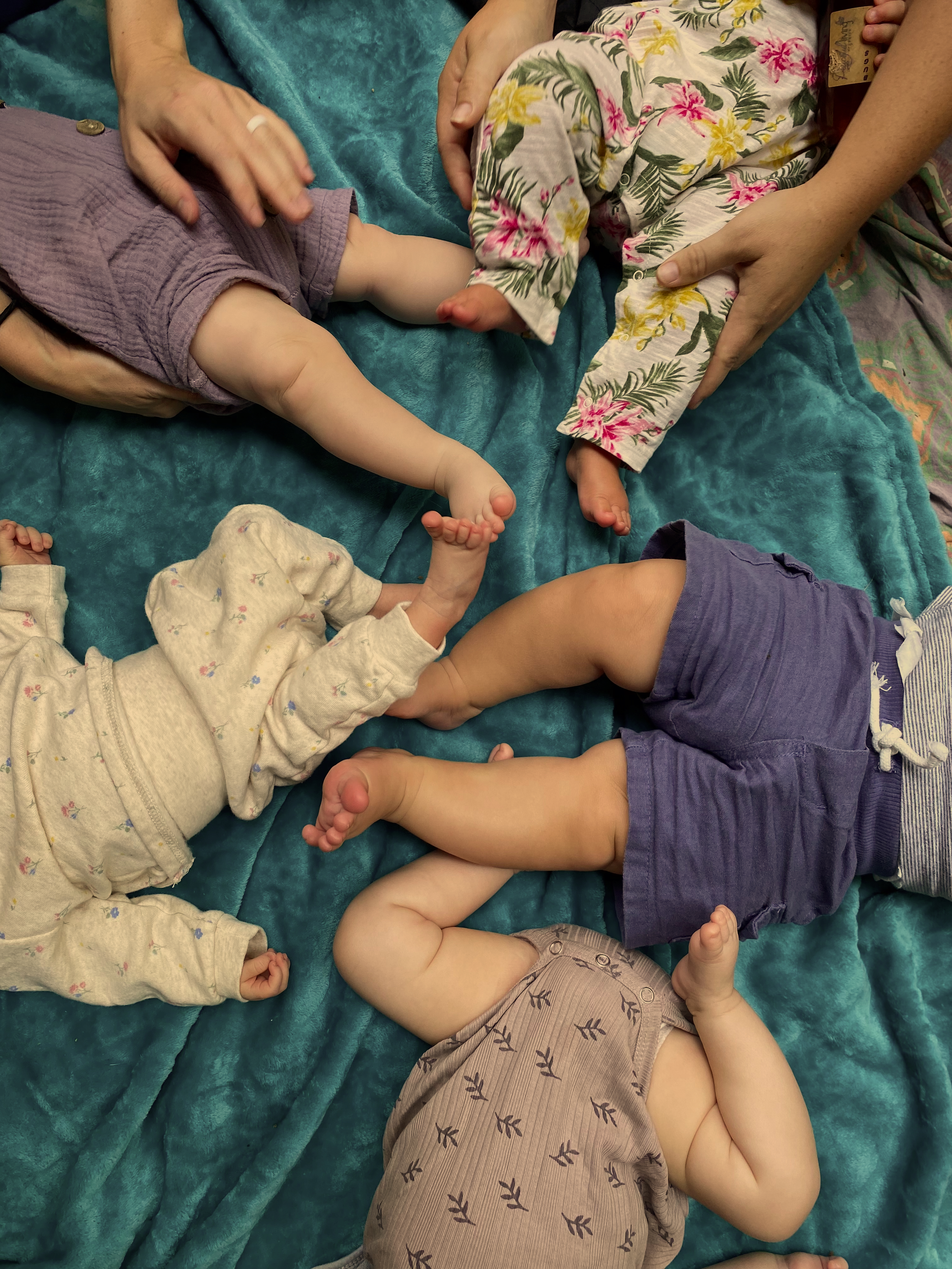 Women gathered around a fire holding babies and connecting during an evening retreat circle