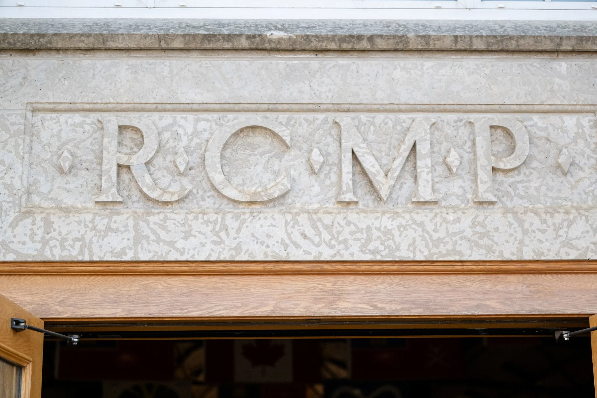 Close-up of a stone wall with the word 'REM' carved in it above a wooden archway.