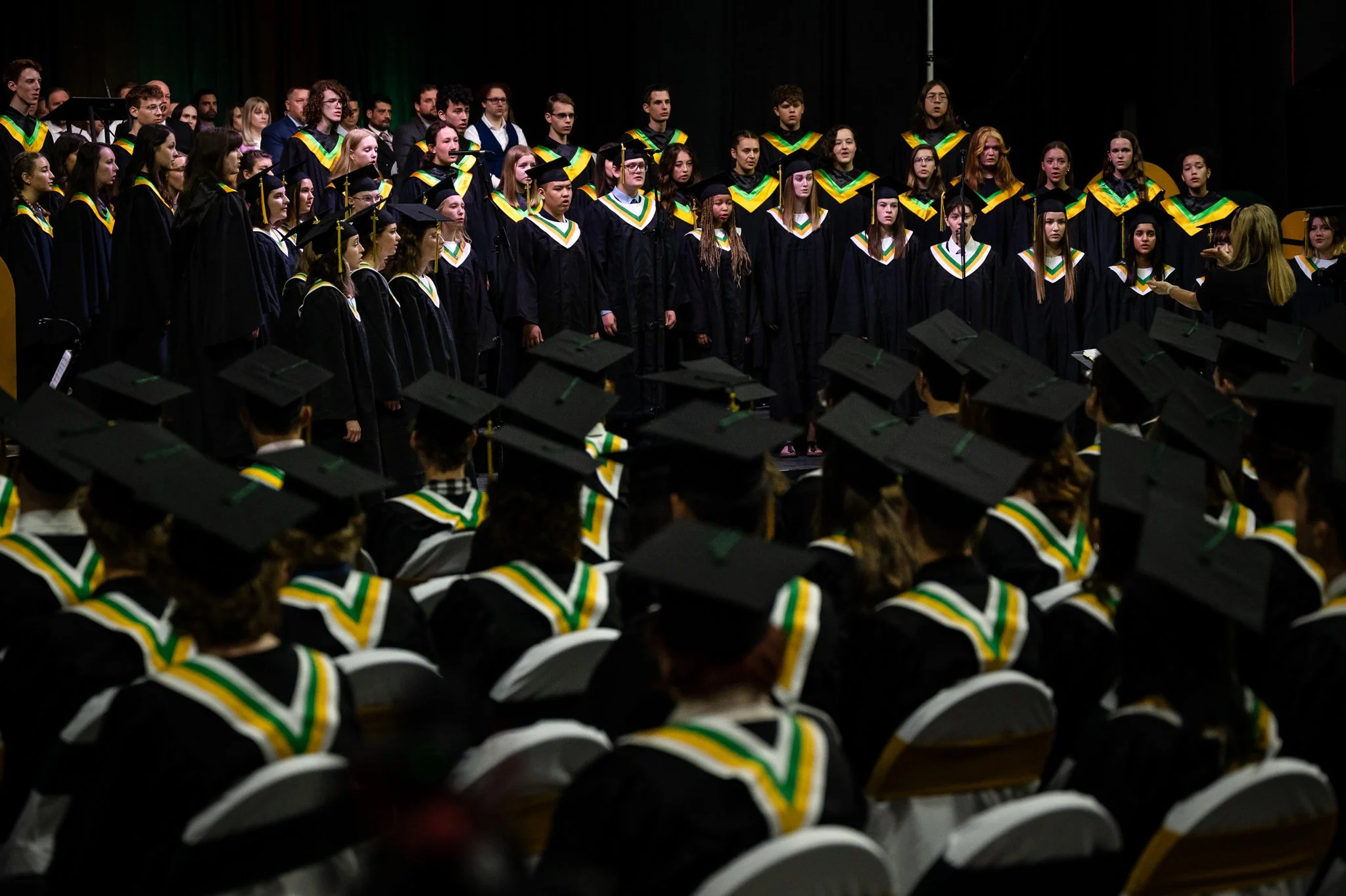 Group of graduates in caps and gowns during a graduation ceremony.