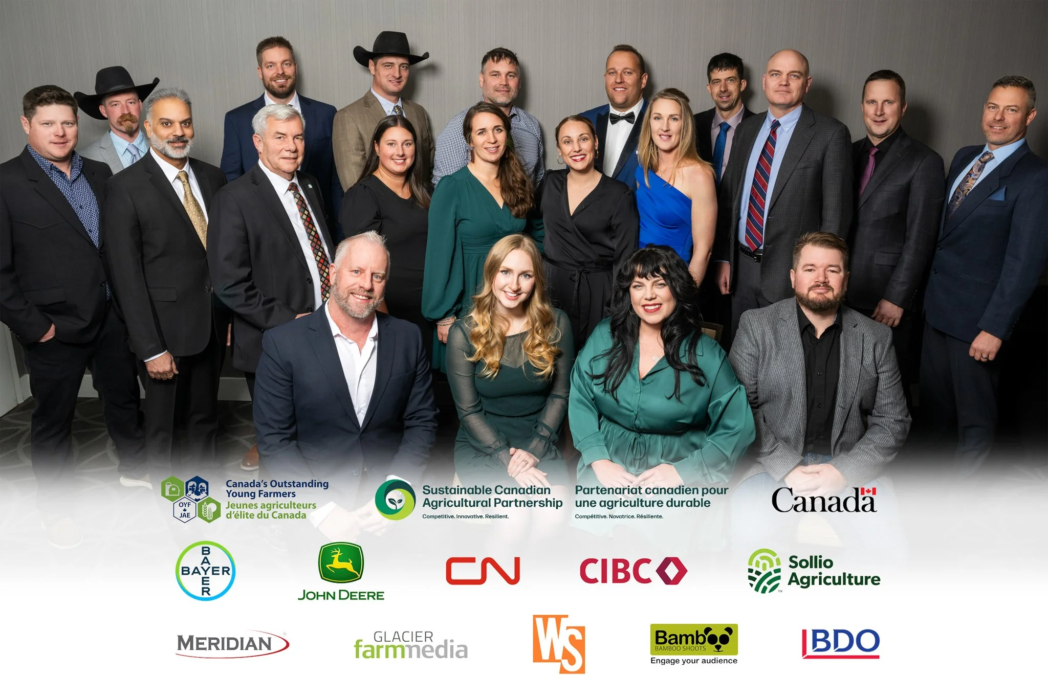 Group of diverse men and women posing for a photo at a corporate or professional event, with logos of various Canadian agricultural and corporate organizations at the bottom.