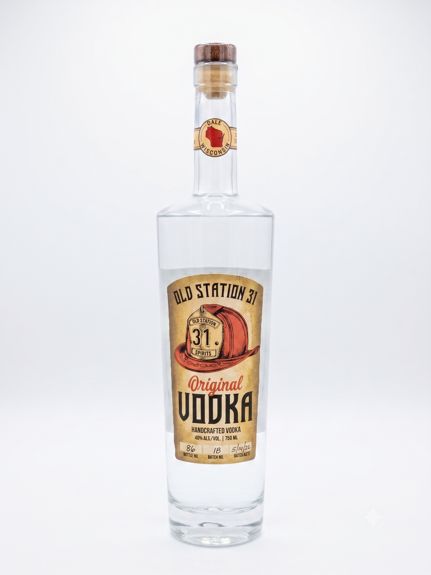 Clear vodka bottle with a label reading 'Old Station 31', featuring a red cowboy hat, and details indicating handcrafted vodka with 40% alcohol, 750 ml. The bottle has a wooden cap and a white background.