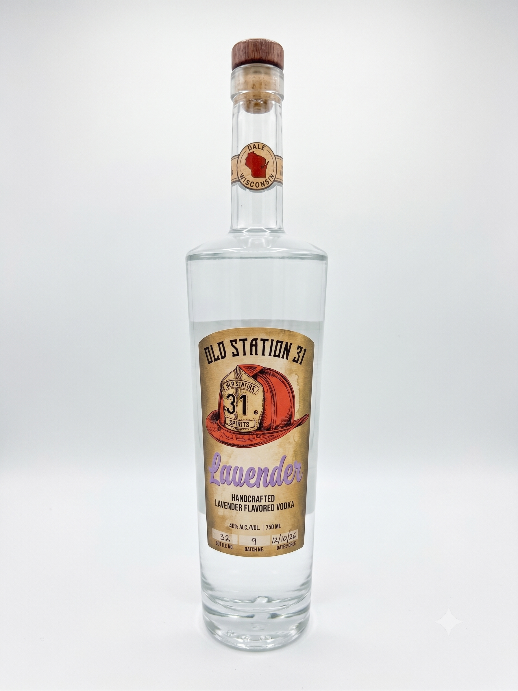 A tall clear vodka bottle with a wooden cap and a label reading 'Old Station 31 Lavender Handcrafted Lavender Flavored Vodka', featuring a vintage illustration of a miner and the words 'Dale Wisconsin' with a red shape of Wisconsin.