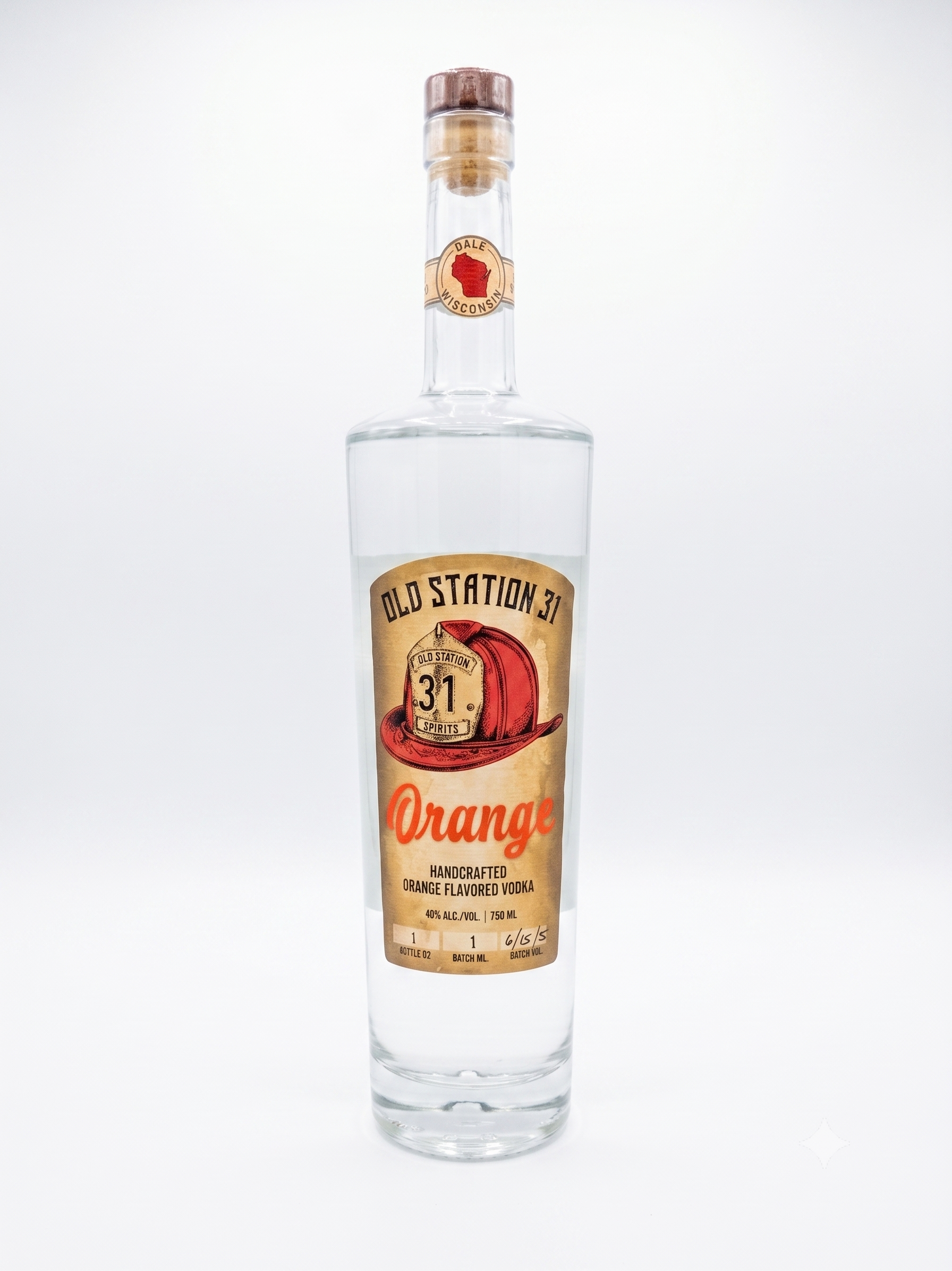 Tall clear bottle of handcrafted orange flavored vodka with a stylized orange and hat label that reads 'Old Station 31 Spirits,' against a plain white background.
