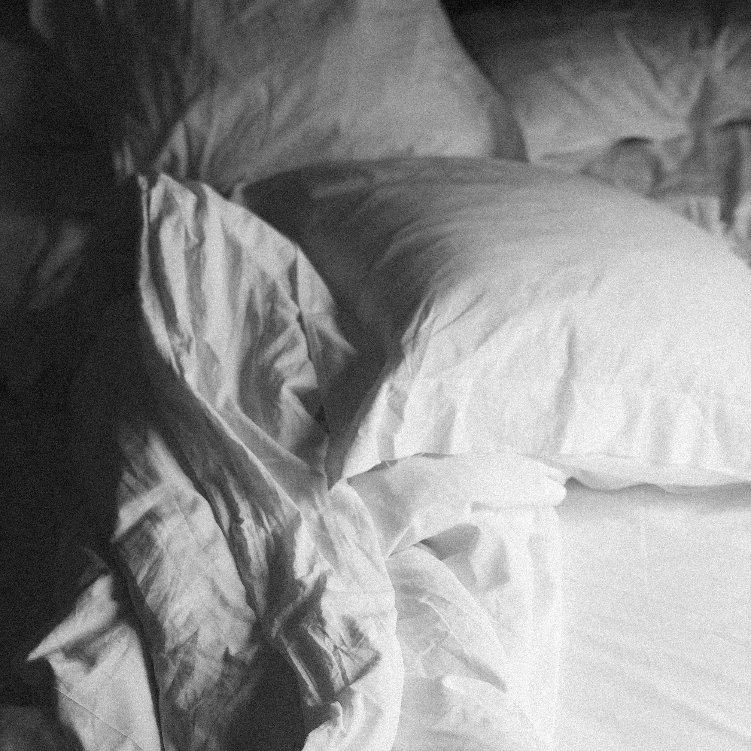 Black and White Photo - Pillow on Messy Bed - Yogi Oil.png