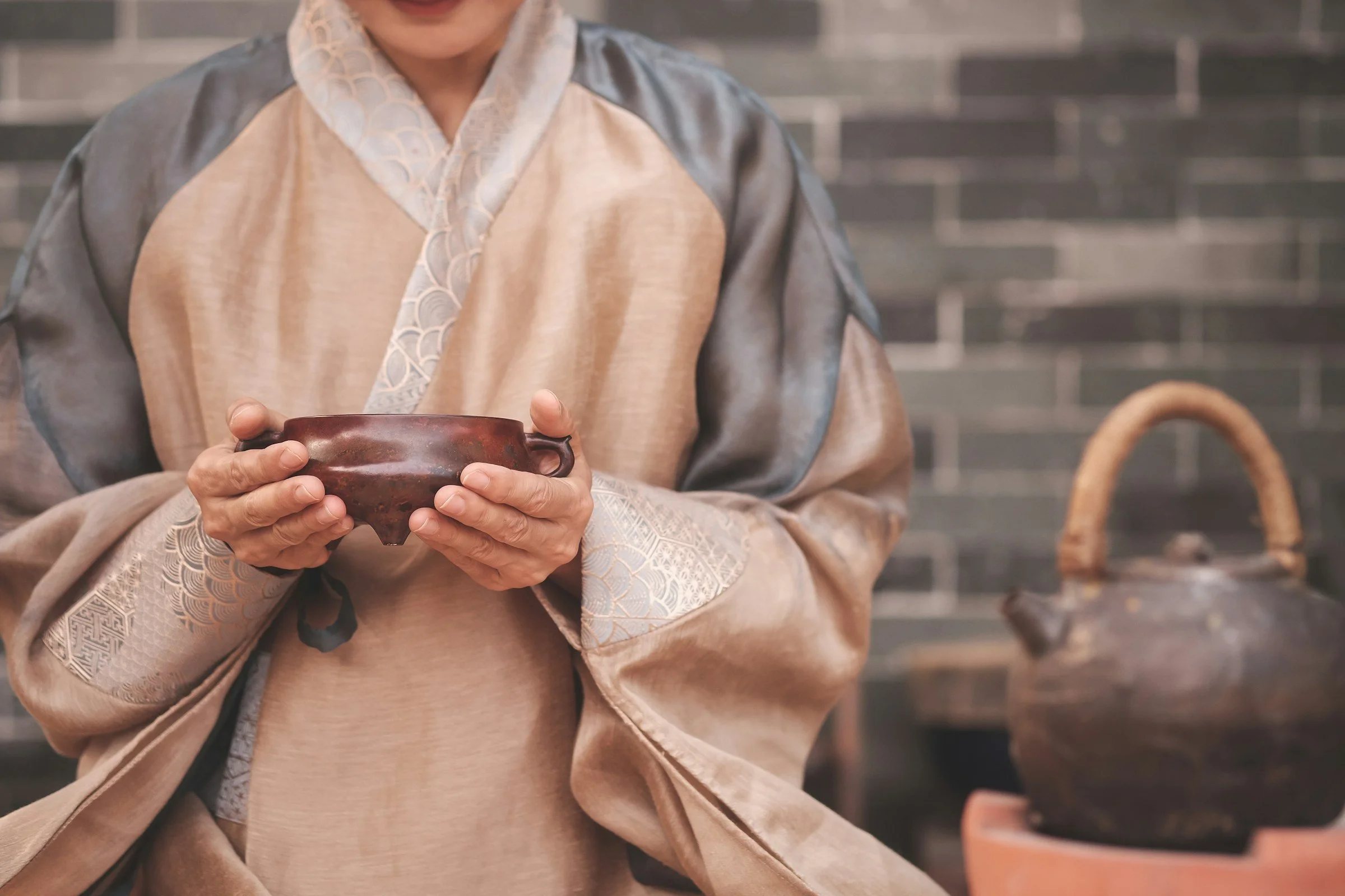 Женщина в светлой одежде держит в руках чашу