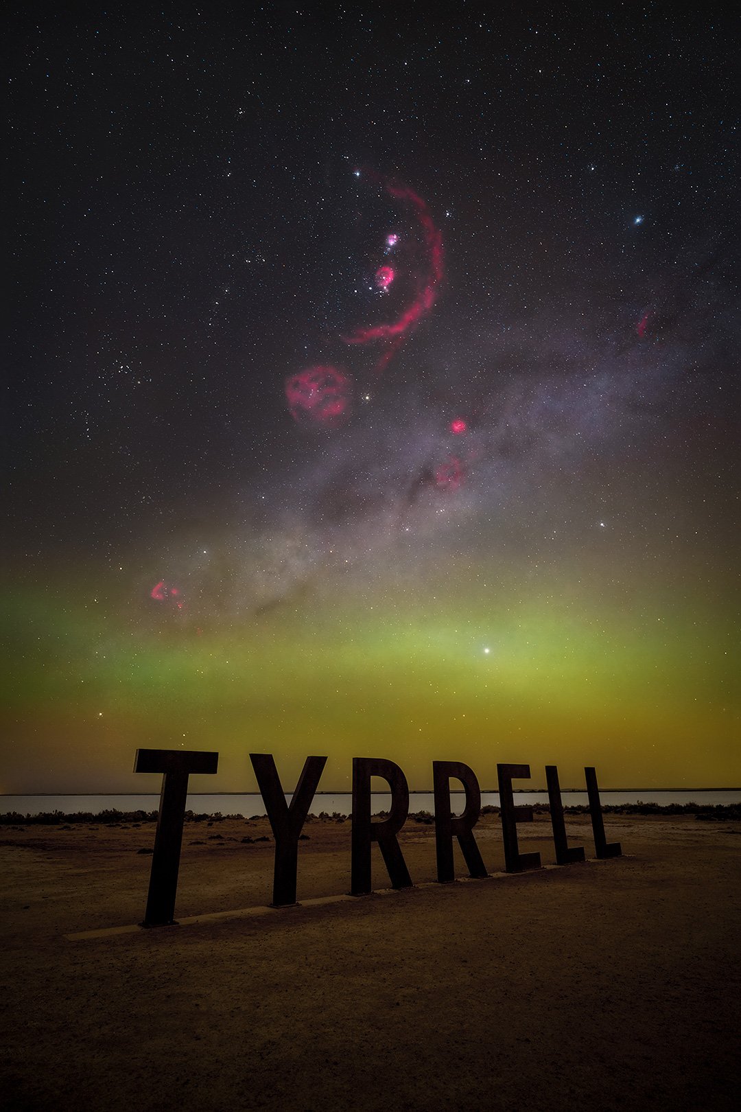 Night sky over the desert with the word 'TYPREH' in large letters in the foreground, featuring vibrant green and purple hues in the aurora borealis, along with stars, nebulae, and the Milky Way galaxy.