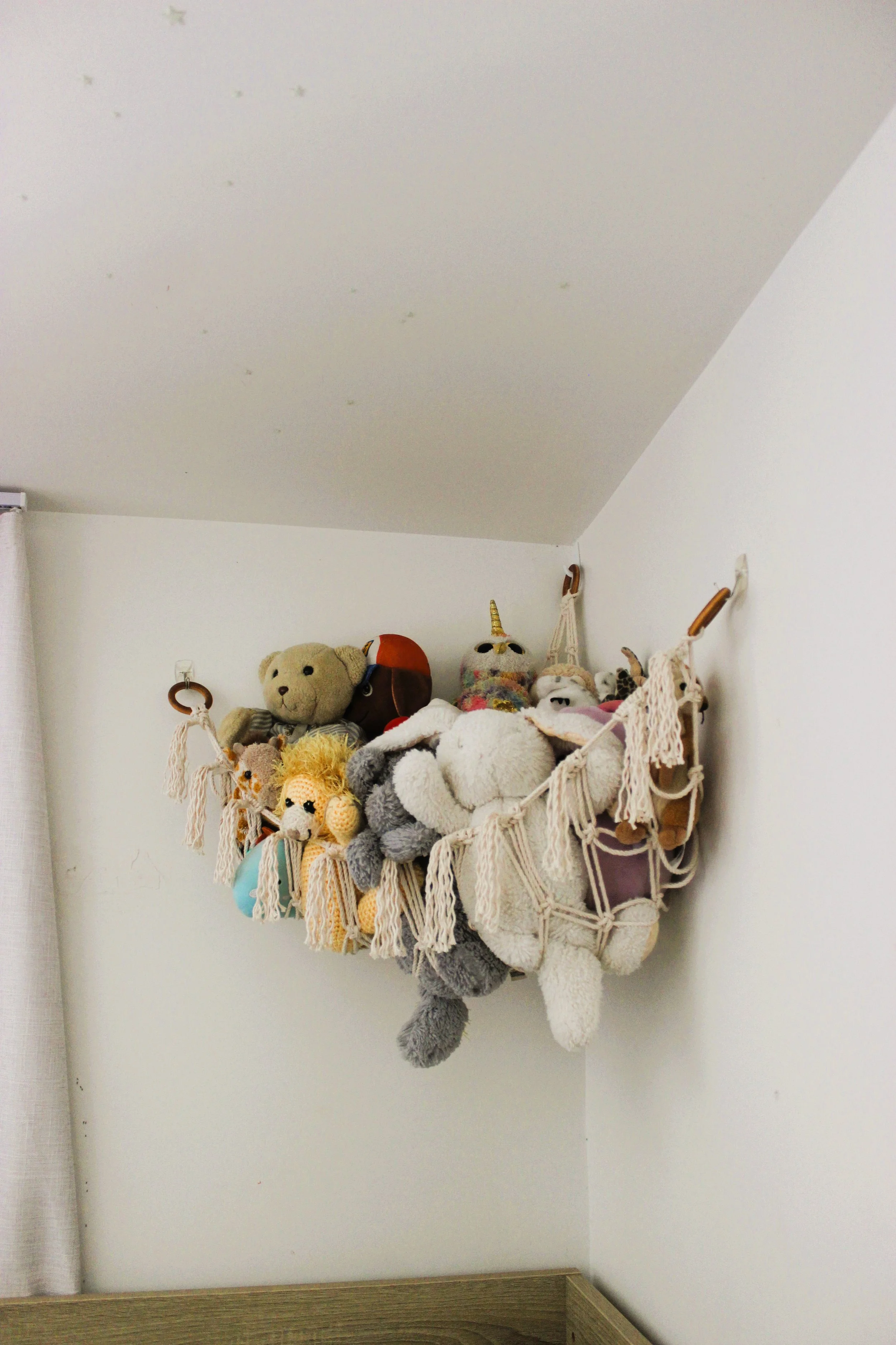 Corner toy hammock hanging in the corner of a childs bedroom.