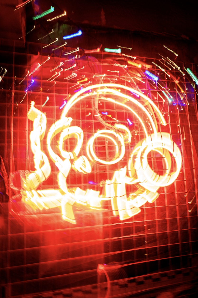 Colorful neon lights in motion, forming the word 'Love' in a vibrant, abstract display on a grid background.