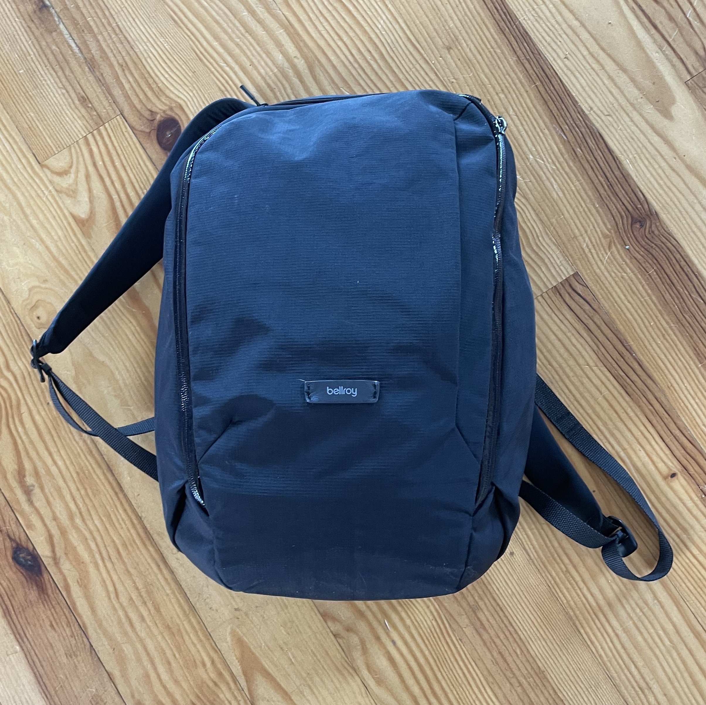a small black rucksack on a wooden floor