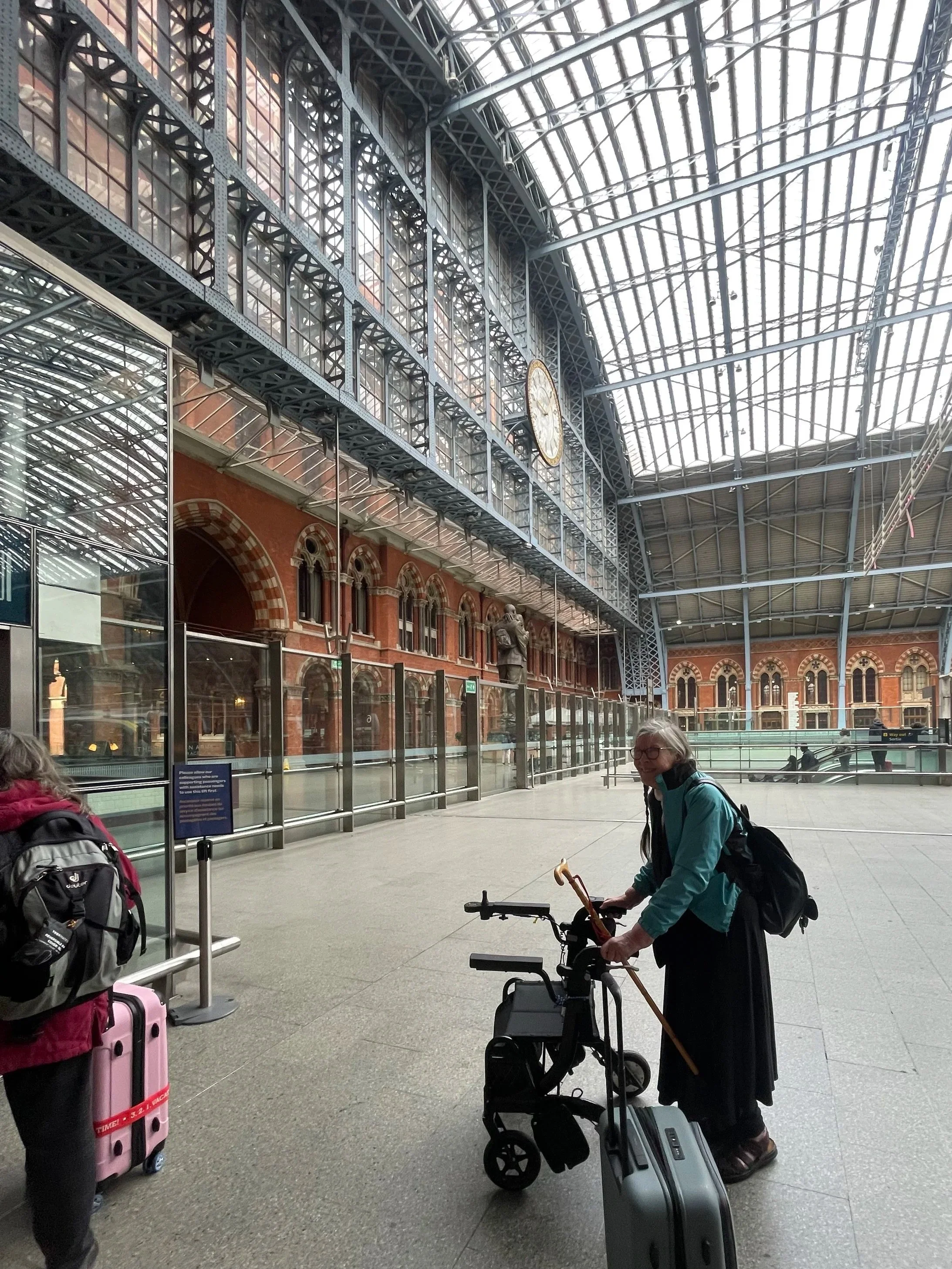 Mum waiting for the lift under the vaulted roof of St Pancras station