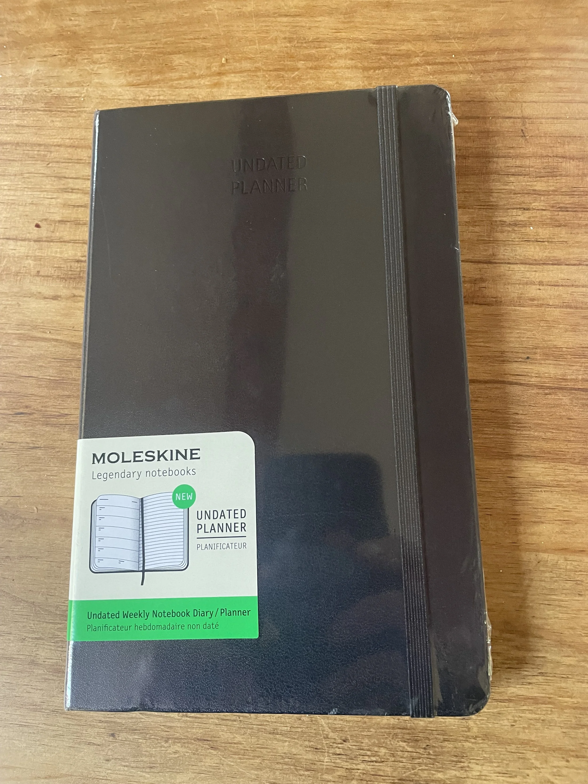 A black Moleskine undated planner in its wrapper
