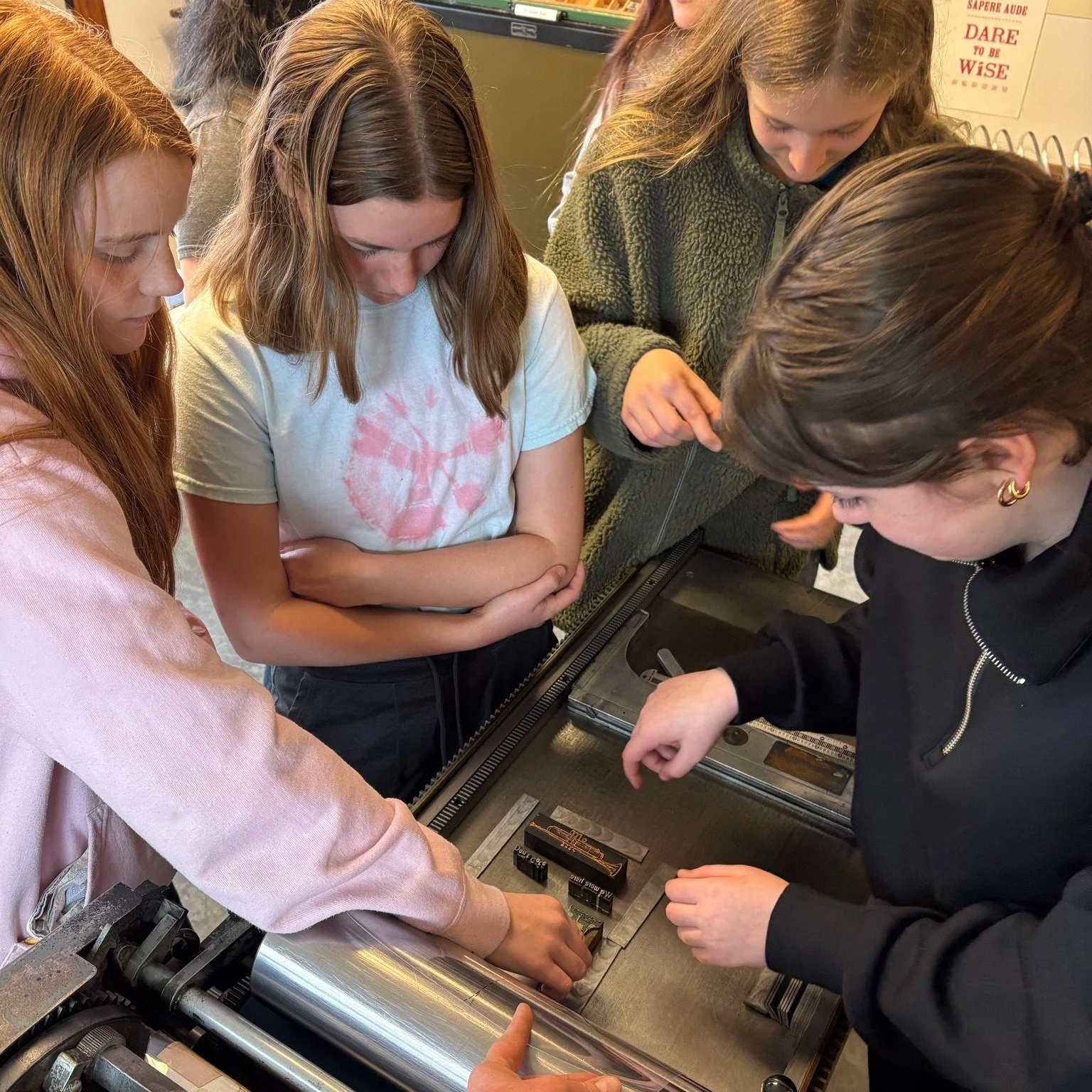 We hosted a lively workshop with a local Girl Scout troop working on their book making badge! First we created a collaborative front cover design. The group decided they would each choose an image, and also a word or phrase meaningful to them. We hel