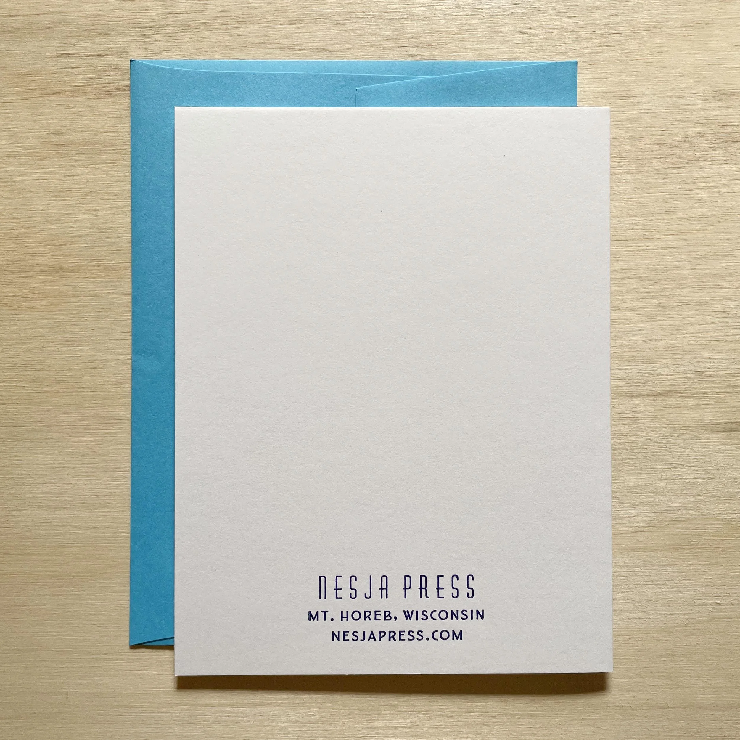 Folded card, closed, showing the back side with the Nesja Press logo and Mt. Horeb, Wisc. letterpress printed in small type near the bottom of the card.