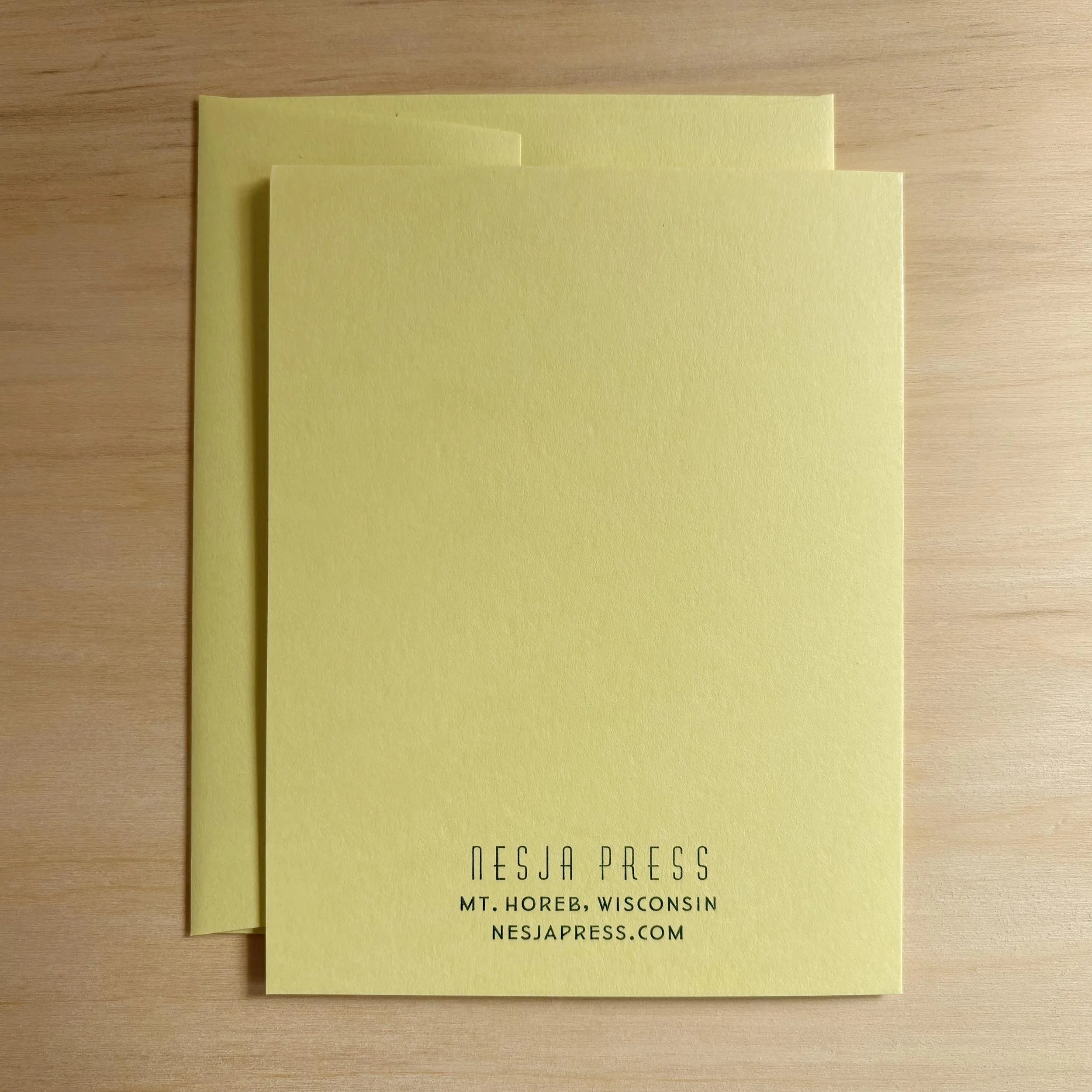Handmade letterpress card printed on light yellow paper with matching envelope. The back of the card shows small green type near the bottom. It reads, 'Nesja Press, Mt. Horeb, Wis., nesjapress.com'