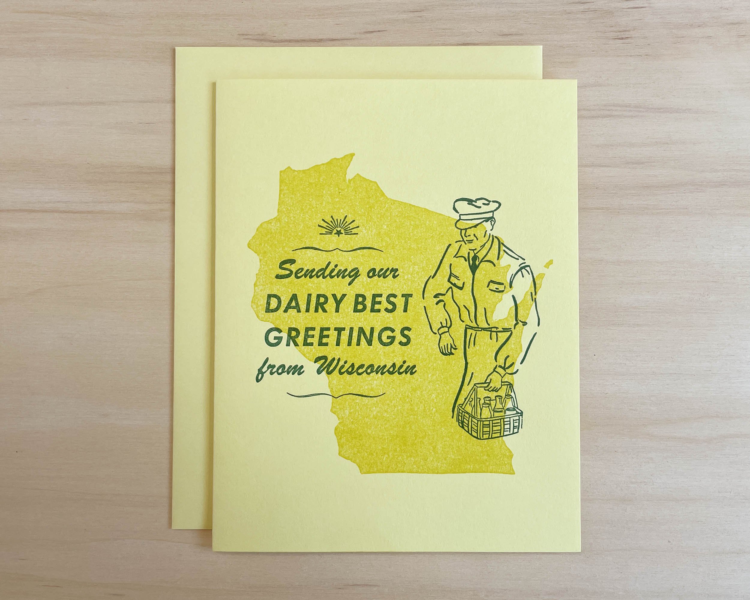 Handmade letterpress card featuring a linocut of Wisconsin, a vintage milk man graphic, and the words Sending our dairy best greetings from Wisconsin