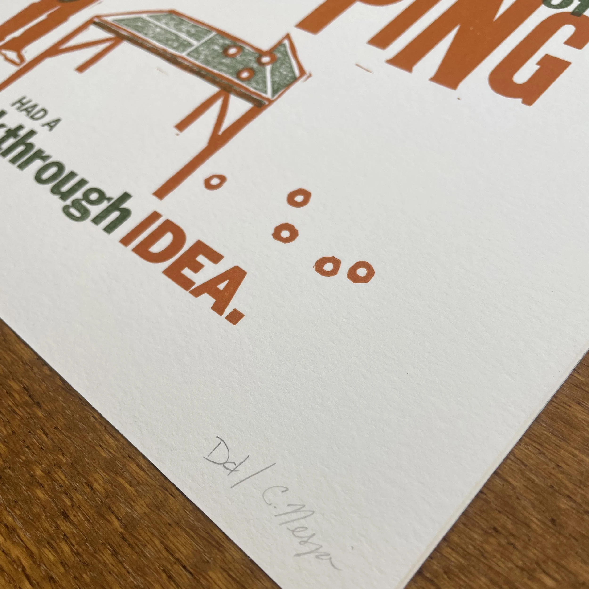 Close up of art print. A ping pong table that ends at the net, balls scattered on floor. Words in various fonts surround, but are not fully readable. Artist signatures in lower right corner.