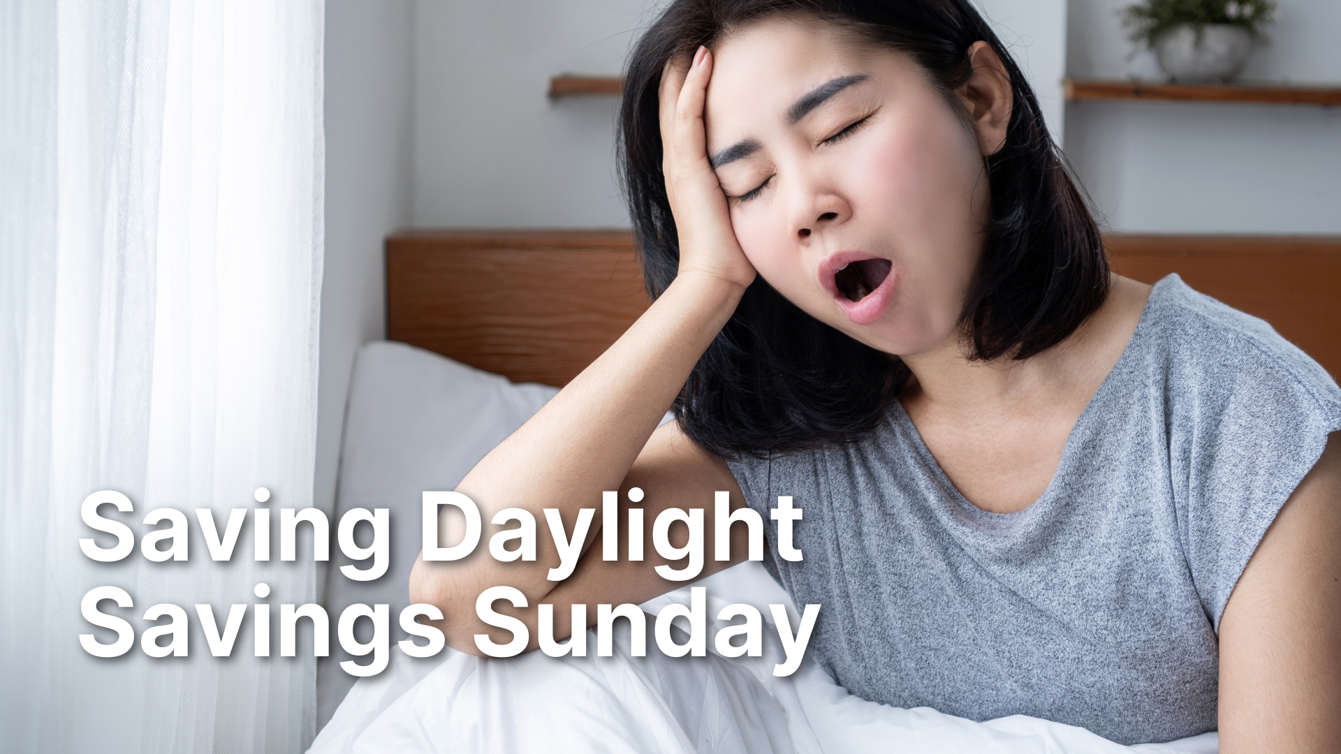 A weary woman sits on the edge of her bed, leaning her head on her hand with a tired expression and yawning. Large, white, bold text at the bottom of the image reads: "Saving Daylight Savings Sunday".