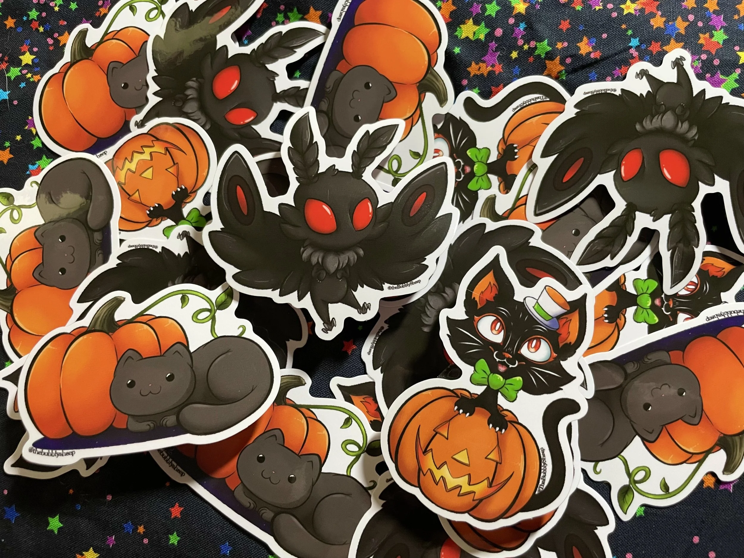 Various Halloween-themed stickers featuring black cats, bats, pumpkins, and cute monsters on a dark, starry background.