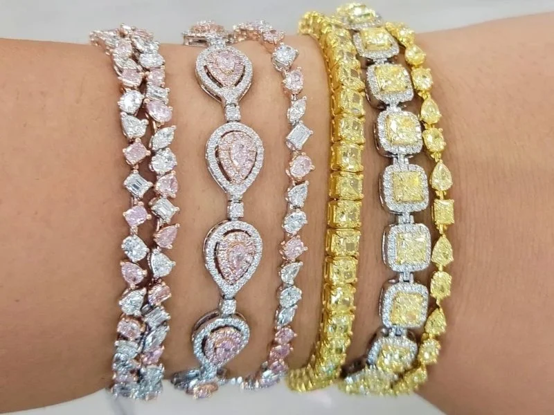 Hourglass Diamonds layered diamond bracelets with pink and yellow stones in pear, cushion, and round cuts.