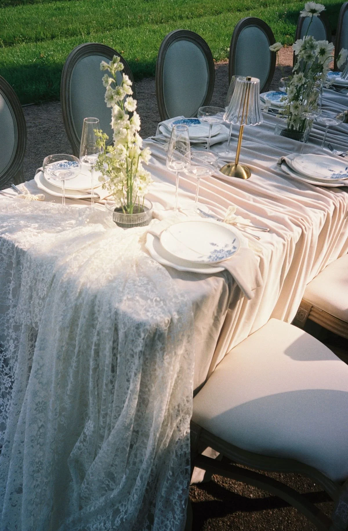 Luxury wedding tablescape with layered linens, textured place settings, and candle groupings