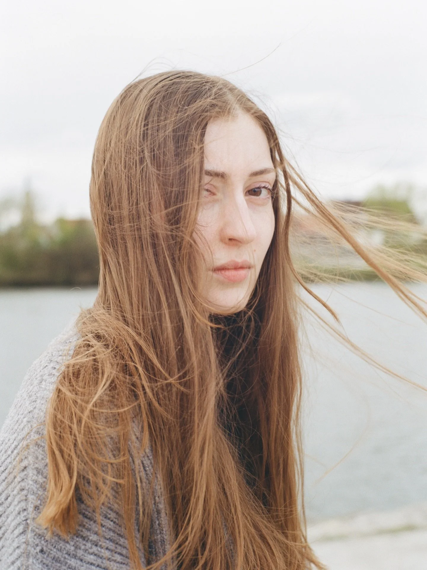 julia, april 2026. ●
portrait of my sister by the river when we were visiting family. &hearts;️

📷 mamiya 645
🎞️ kodak gold
⏱️ dev&amp;scan by @khrome_hamburg
