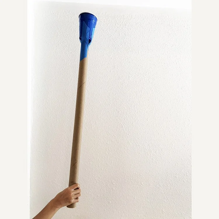 Child's hand holding a handmade snack grabber made from a wrapping paper roll