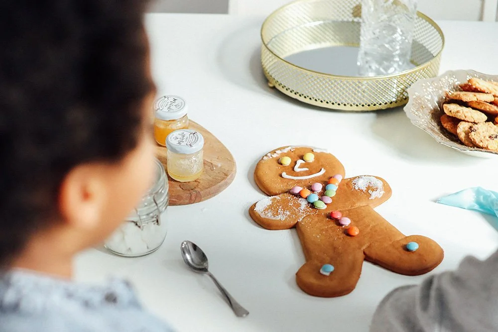 Decorated gingerbread cookie with child looking on