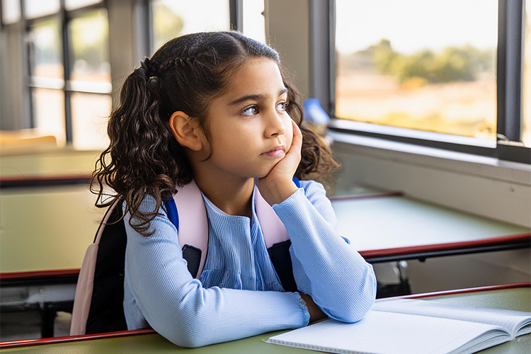elementary school student looking out of a classroom window