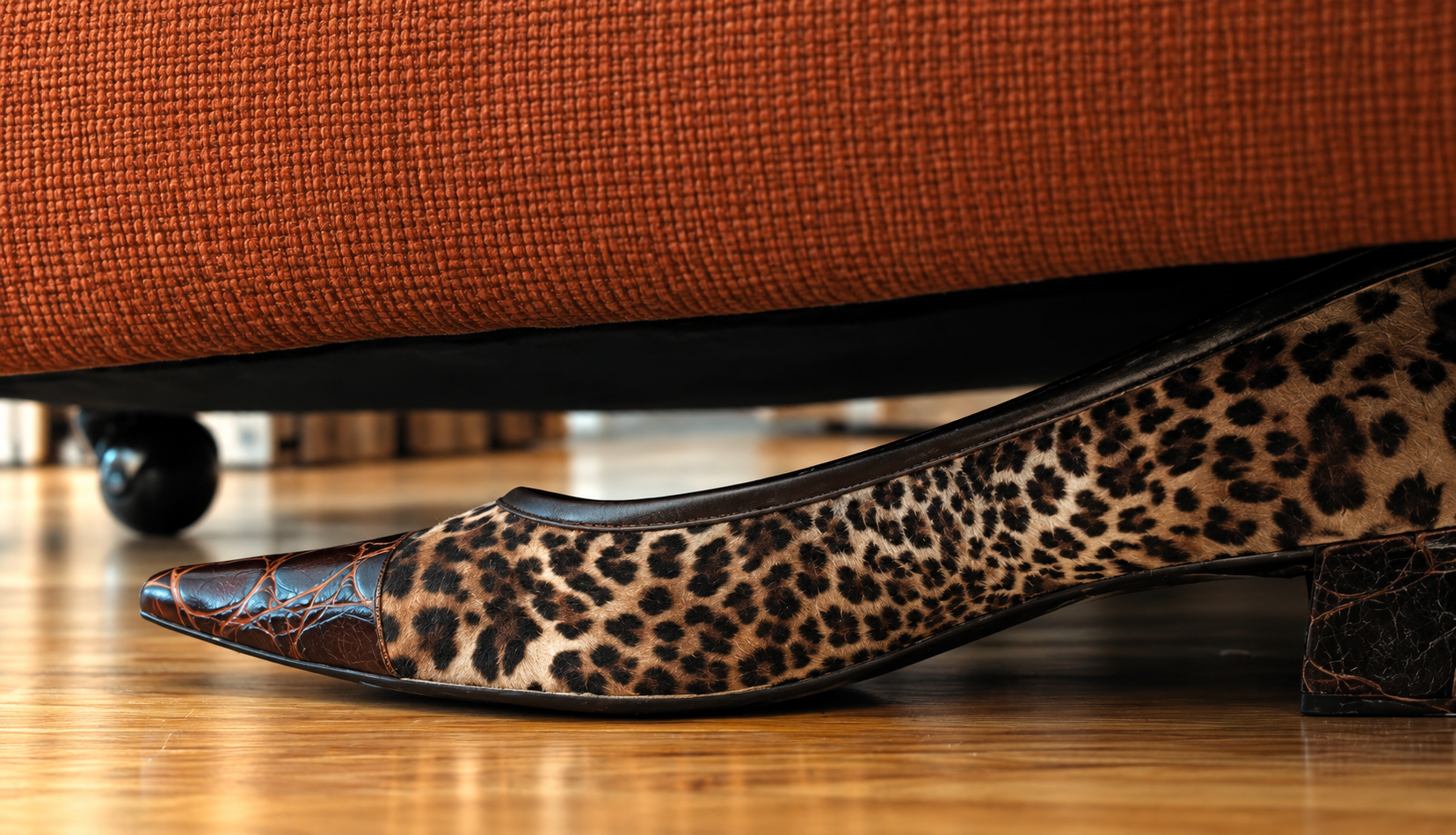 leopard print heals under a burnt orange ottoman