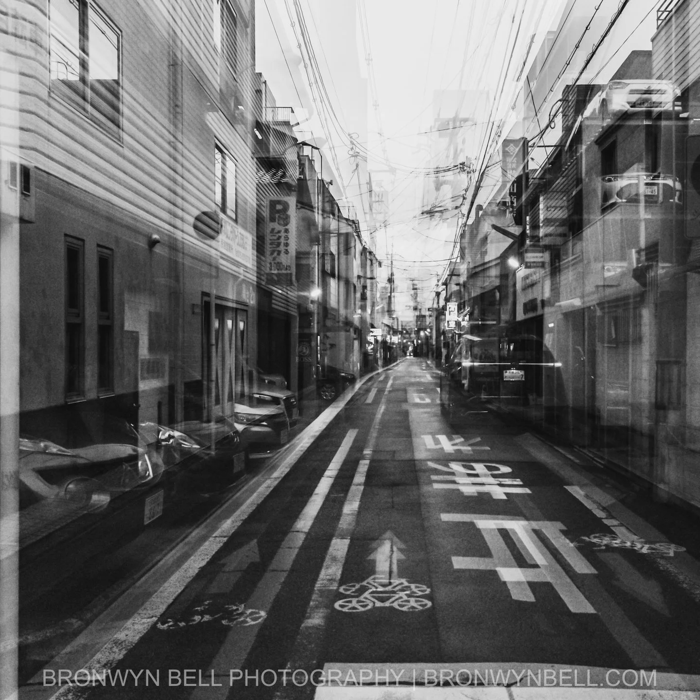 Narrow facades and tiled eaves merge into a collage of angles and textures, the multi-exposure drawing the viewer’s eye through the maze of power lines above. Every frame feels like a page from a memory that refuses to fade.