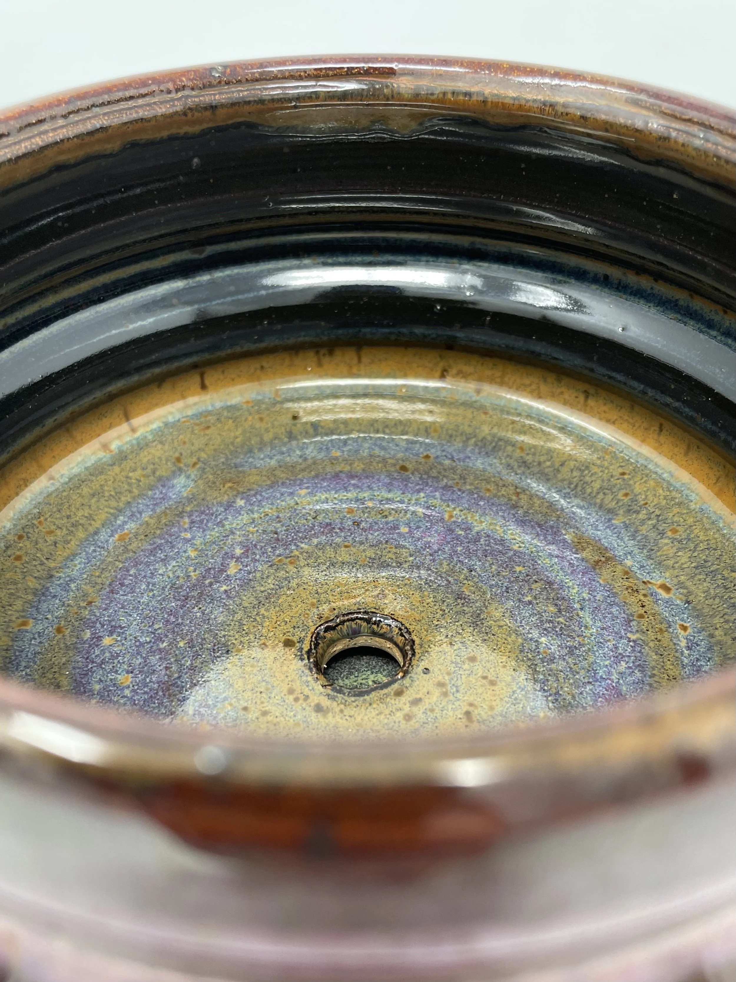 Close-up of the inside of a rusty, discolored metal can showing the bottom with rust and corrosion marks.