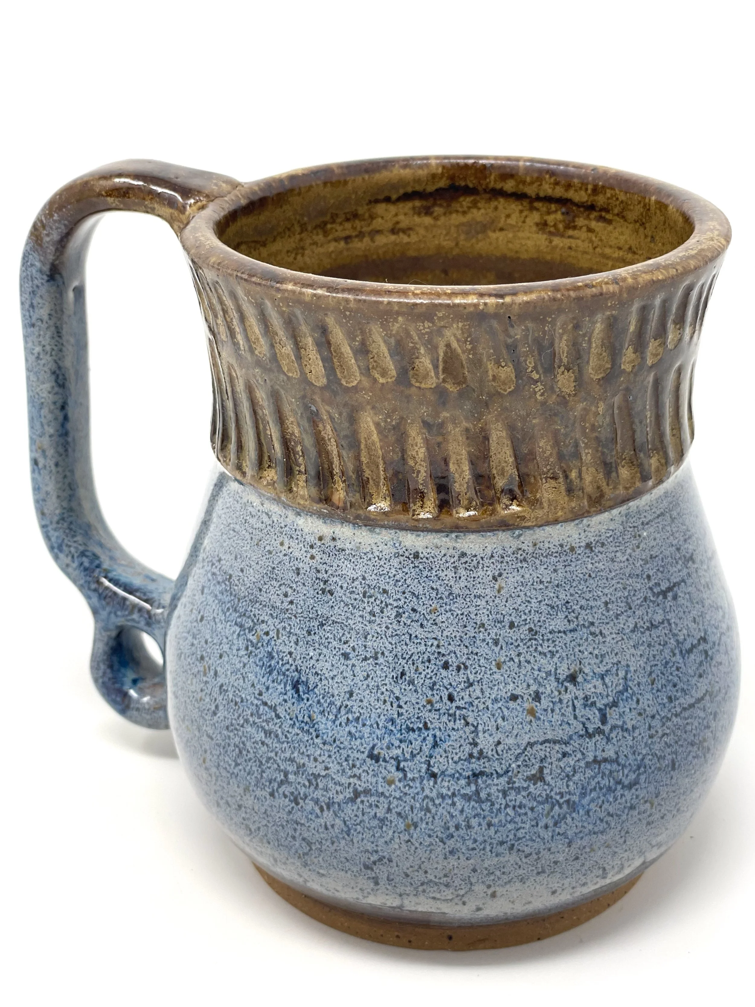 A ceramic mug with a light blue speckled lower half and a brown, ribbed upper half, with a curved handle.